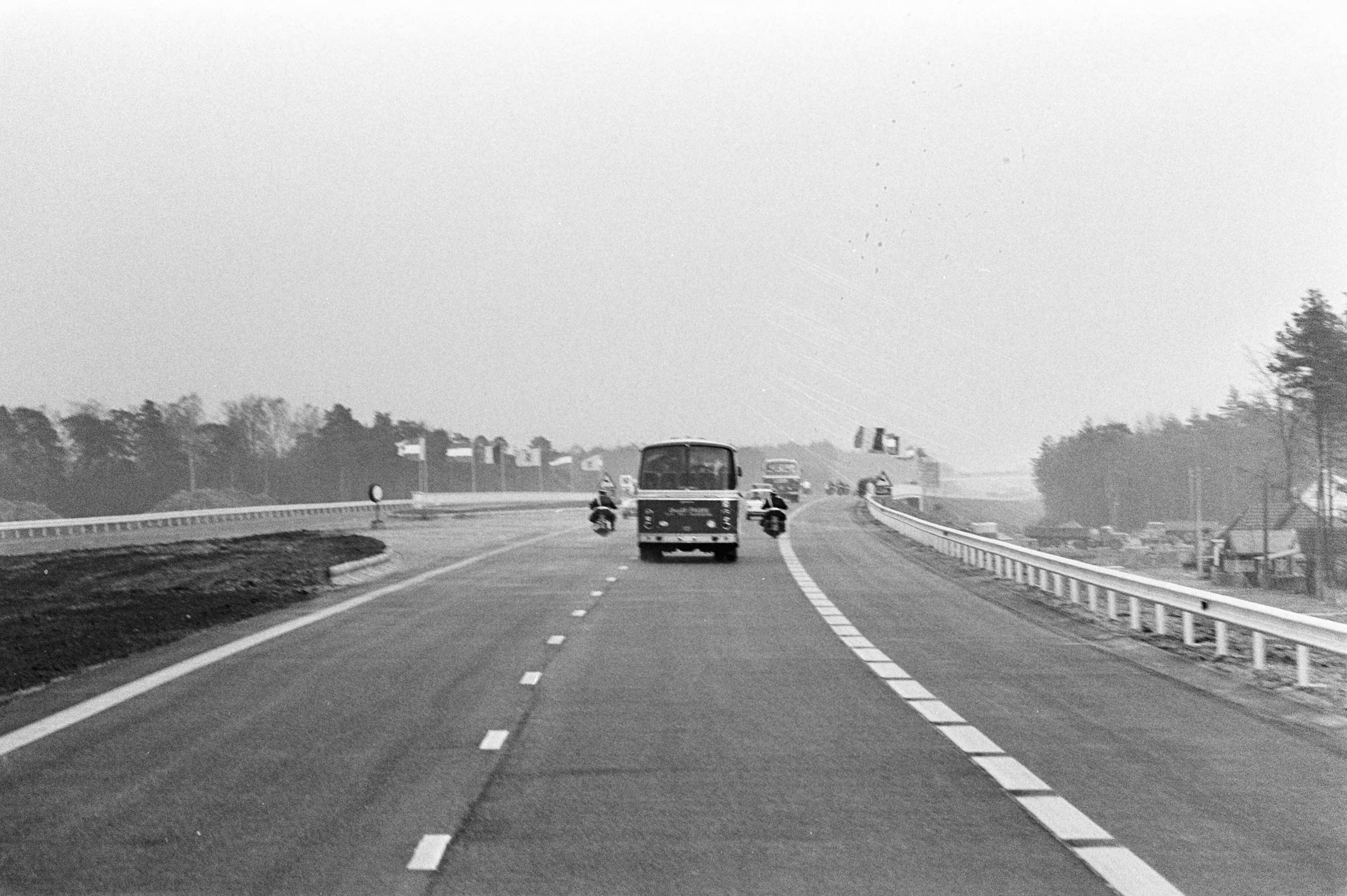 Opening van de E10, de nieuwe snelweg tussen Breda en Antwerpen, door — De bus met daarin koningin Juliana en koning Boudewijn op de nieuwe weg — Foto: Fotograaf Onbekend / Anefo. Licentie: Set B: Rechtenvrij / Publiek Domein. Bron: Nationaal Archief. http://hdl.handle.net/10648/abde5aa4-d0b4-102d-bcf8-003048976d84
