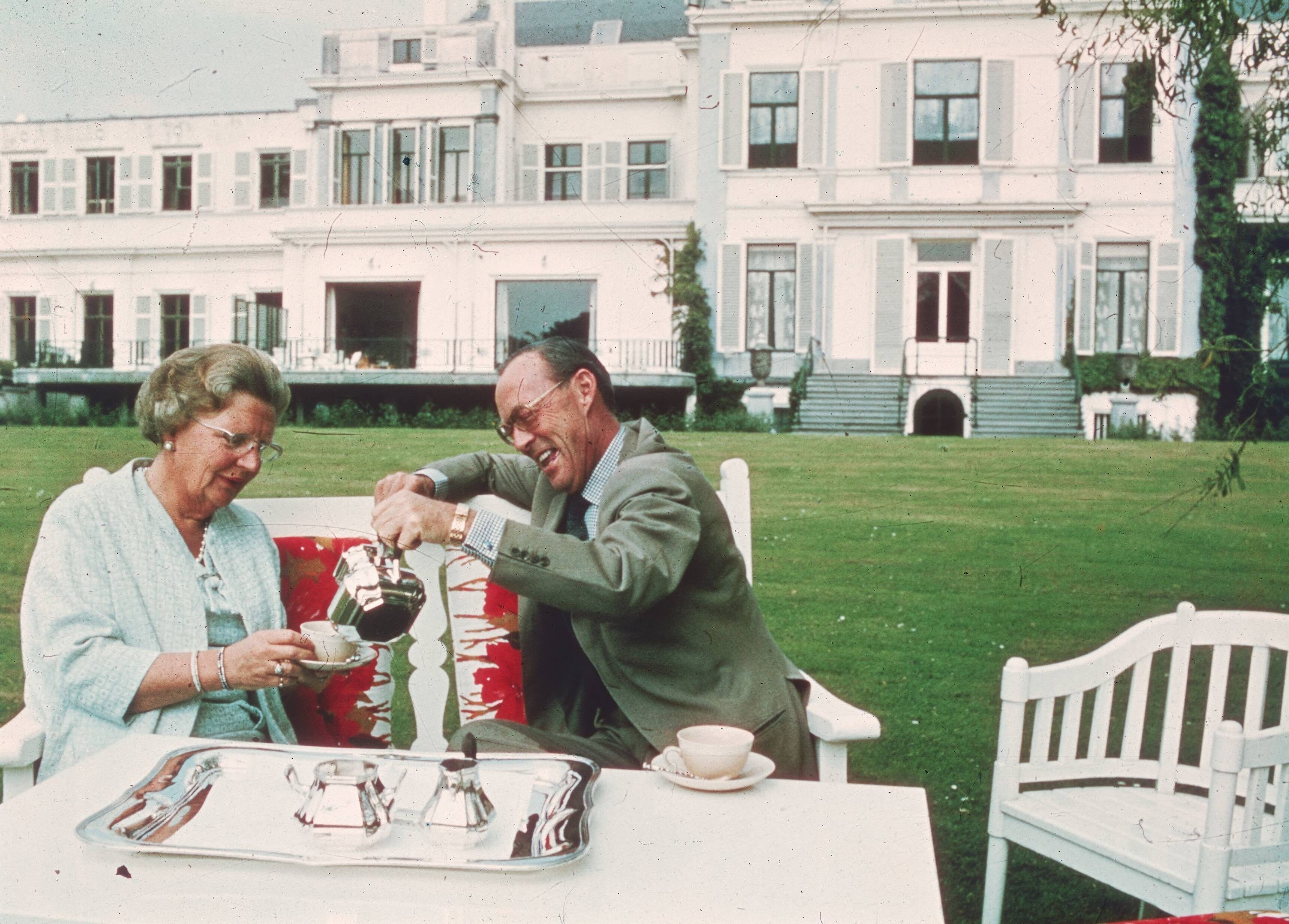 Fotocollectie RVD / Koninklijk Huis — Prins Bernhard schenkt koningin Juliana koffie in, in de achtertuin van paleis Soestdijk, voorjaar 1972 — Foto: Rousel (repro) / RVD. Licentie: Set B: Rechtenvrij / Publiek Domein. Bron: Nationaal Archief. http://hdl.handle.net/10648/afb4741a-d0b4-102d-bcf8-003048976d84