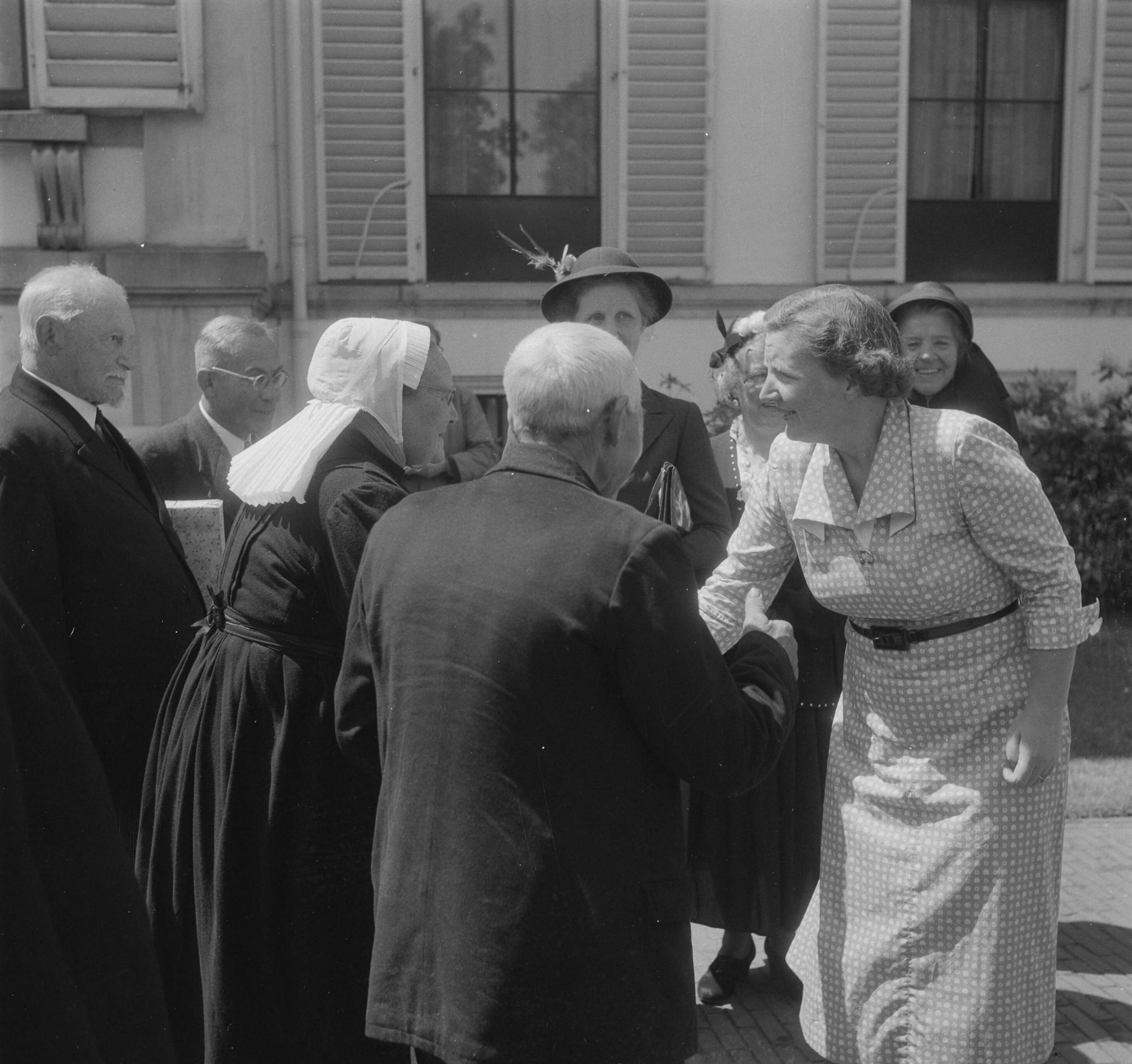 Bezoek Puttenaren aan Soestdijk — Bezoek van 165 ouden van dagen uit Putten aan paleis Soestdijk. De heer en mevrouw Van de Broek-Tomassen boden koningin Juliana een mandje met eieren en een bundeltje Puttener moppen aan. Links de heer Van Veen, een oud Lombok strijder — Foto: Noske, J.D. / Anefo. Licentie: Set B: Rechtenvrij / Publiek Domein. Bron: Nationaal Archief. http://hdl.handle.net/10648/a8eb83f8-d0b4-102d-bcf8-003048976d84