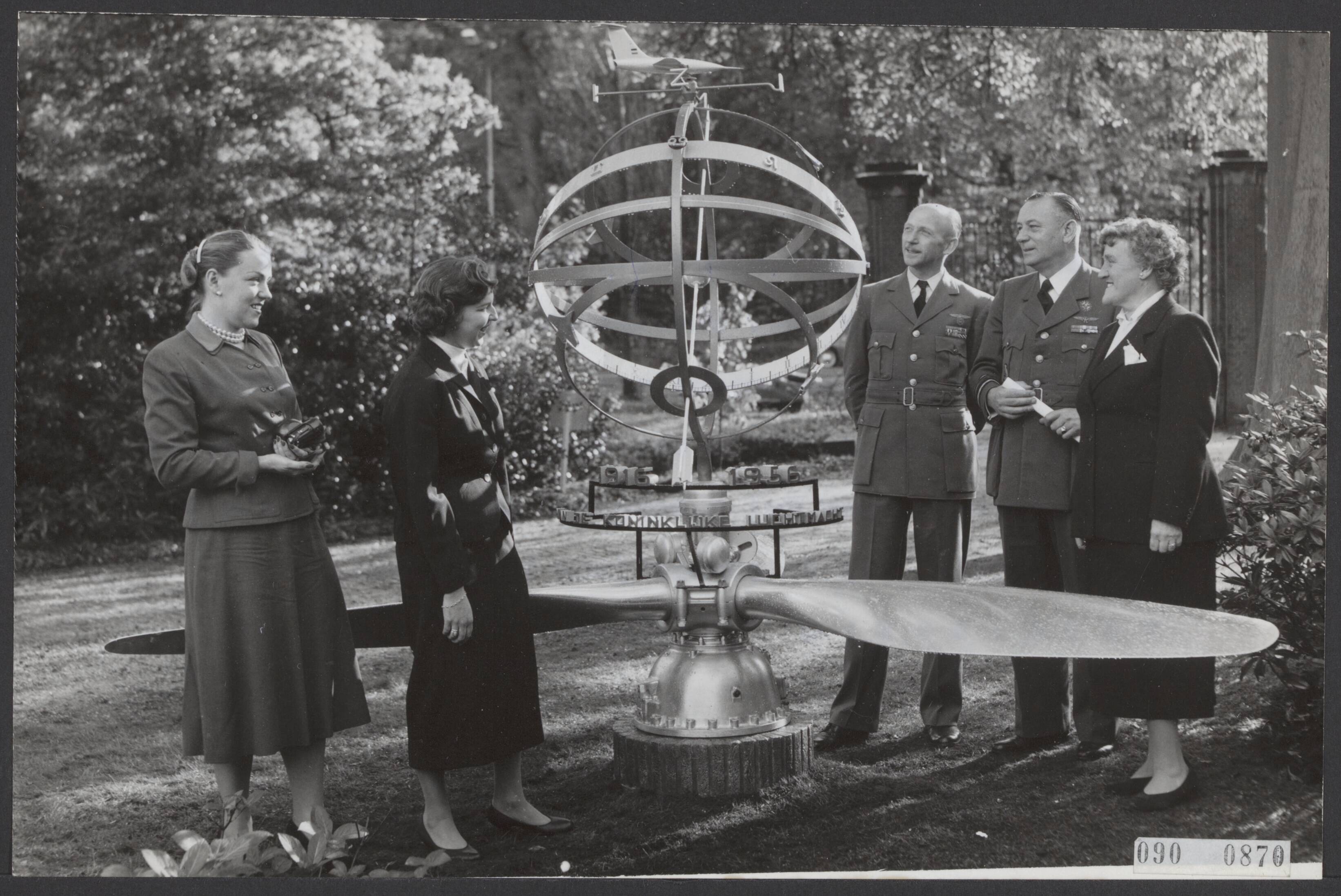 Fotocollectie Elsevier Binnenland — Ten huize van luitenant-generaal A. Baretta te Wassenaar werd hem bij zijn afscheid als chef Luchtmachtstaf namens het personeel van de Koninklijke Luchtmacht een zonnewijzer aangeboden. Vlnr. de twee dochters van de generaal, de nieuwe chef Luchtmachtstaf gen.maj. Schaper, Lt. Gen. A. Baretta en mevr. Baretta bij de zonnewijzer in de tuin — Foto: Fotograaf Onbekend / Anefo. Licentie: Set B: Rechtenvrij / Publiek Domein. Bron: Nationaal Archief. http://hdl.handle.net/10648/ae1d386c-d0b4-102d-bcf8-003048976d84