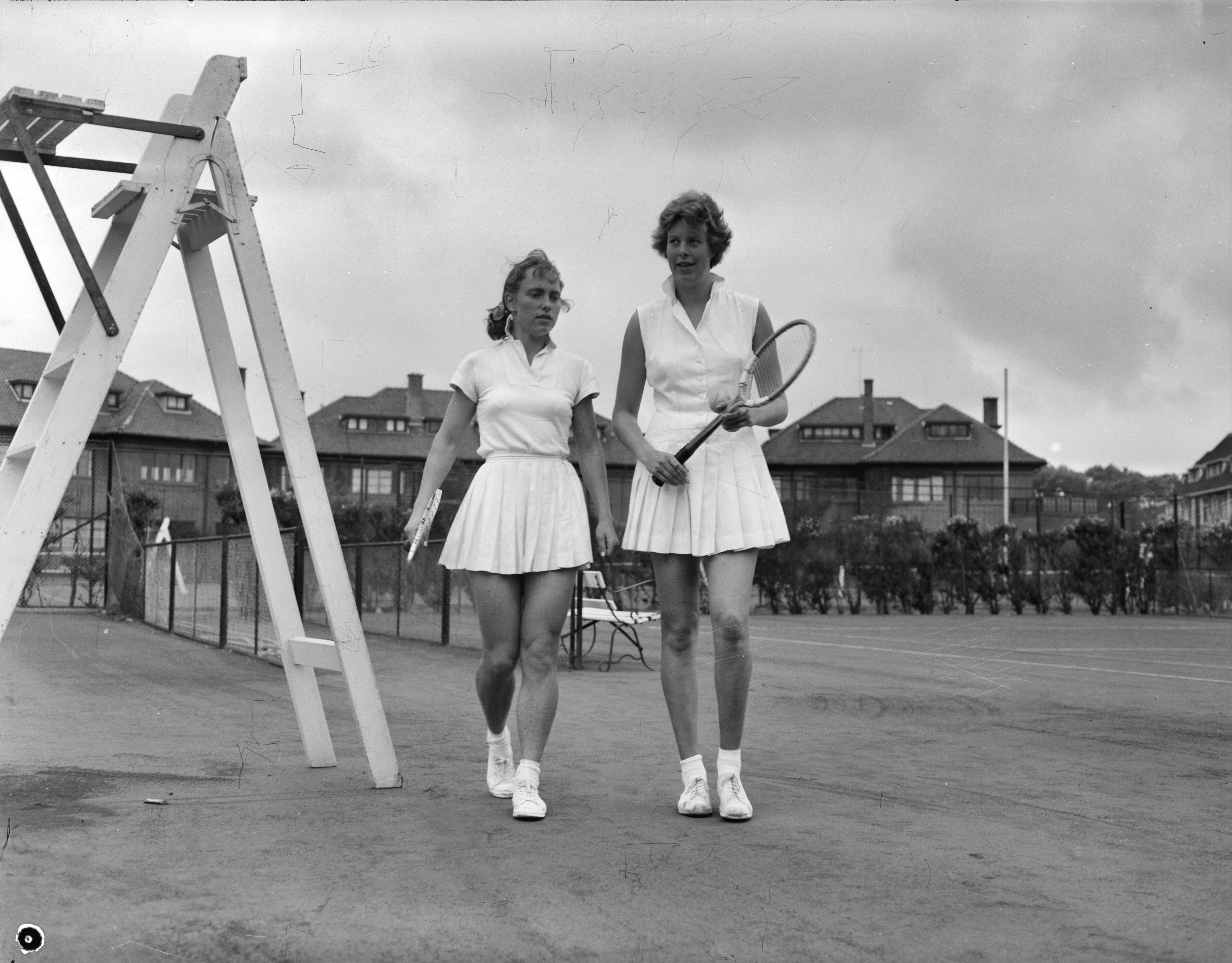 Fotocollectie Anefo — Nederlandse tenniskampioenschappen op de METS-banen te Scheveningen. Mej. J. Wienese (links) en mej. F. Marinkelle (rechts) — Foto: Rossem, Wim van / Anefo. Licentie: Set B: Rechtenvrij / Publiek Domein. Bron: Nationaal Archief. http://hdl.handle.net/10648/a94d6866-d0b4-102d-bcf8-003048976d84