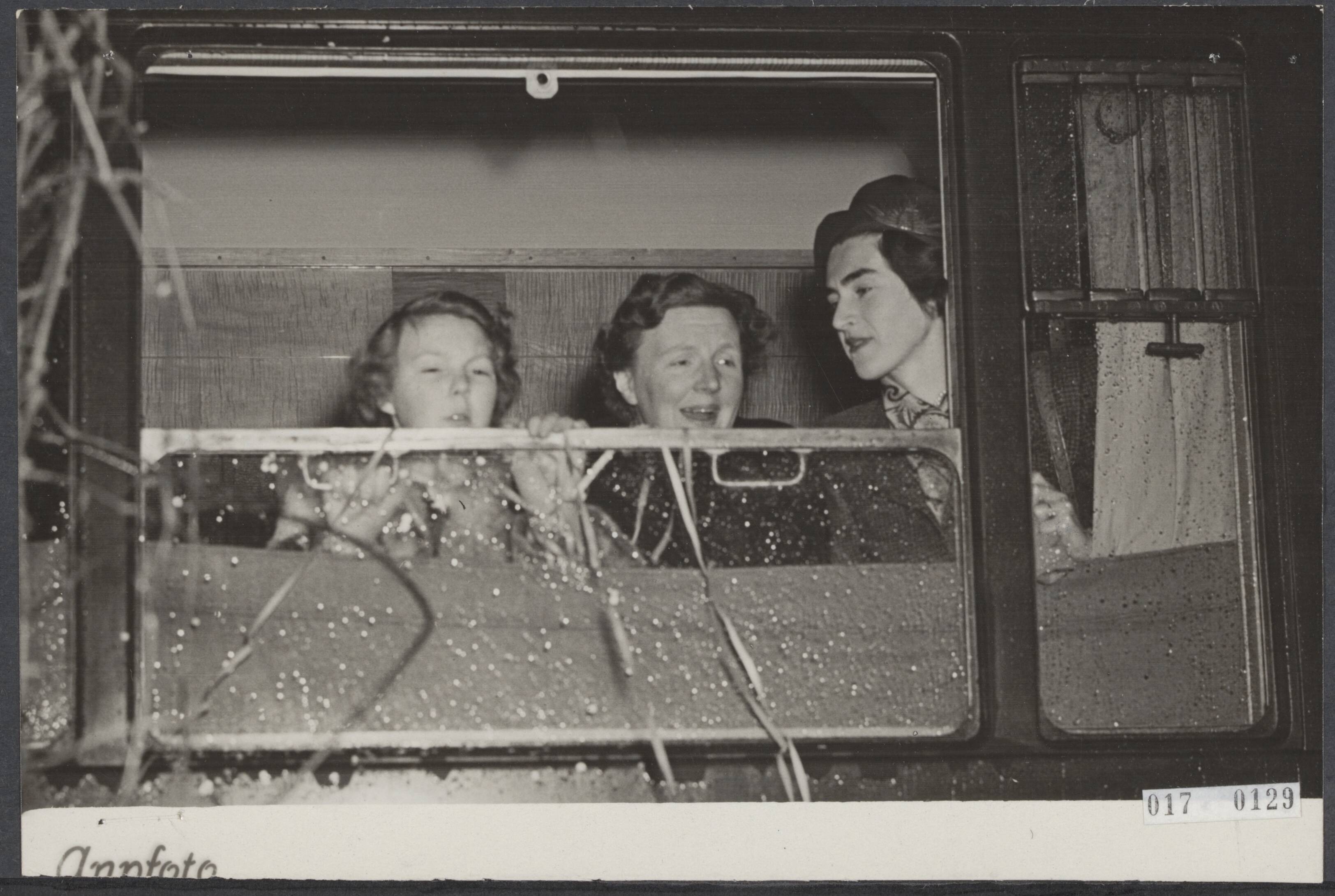 Fotocollectie Elsevier Binnenland — Koningin Juliana en de drie oudste prinsesjes zijn van het station Baarn vertrokken voor de vakantiereis naar Sankt Anton. Voor het geopende raam koningin Juliana, prinses Beatrix en mevr. Van Maasdijk, de echtgenote van de algemene secretaris van de koningin — Foto: ANP / RVD of rechtenvrij. Licentie: Set B: Rechtenvrij / Publiek Domein. Bron: Nationaal Archief. http://hdl.handle.net/10648/adbcd8aa-d0b4-102d-bcf8-003048976d84