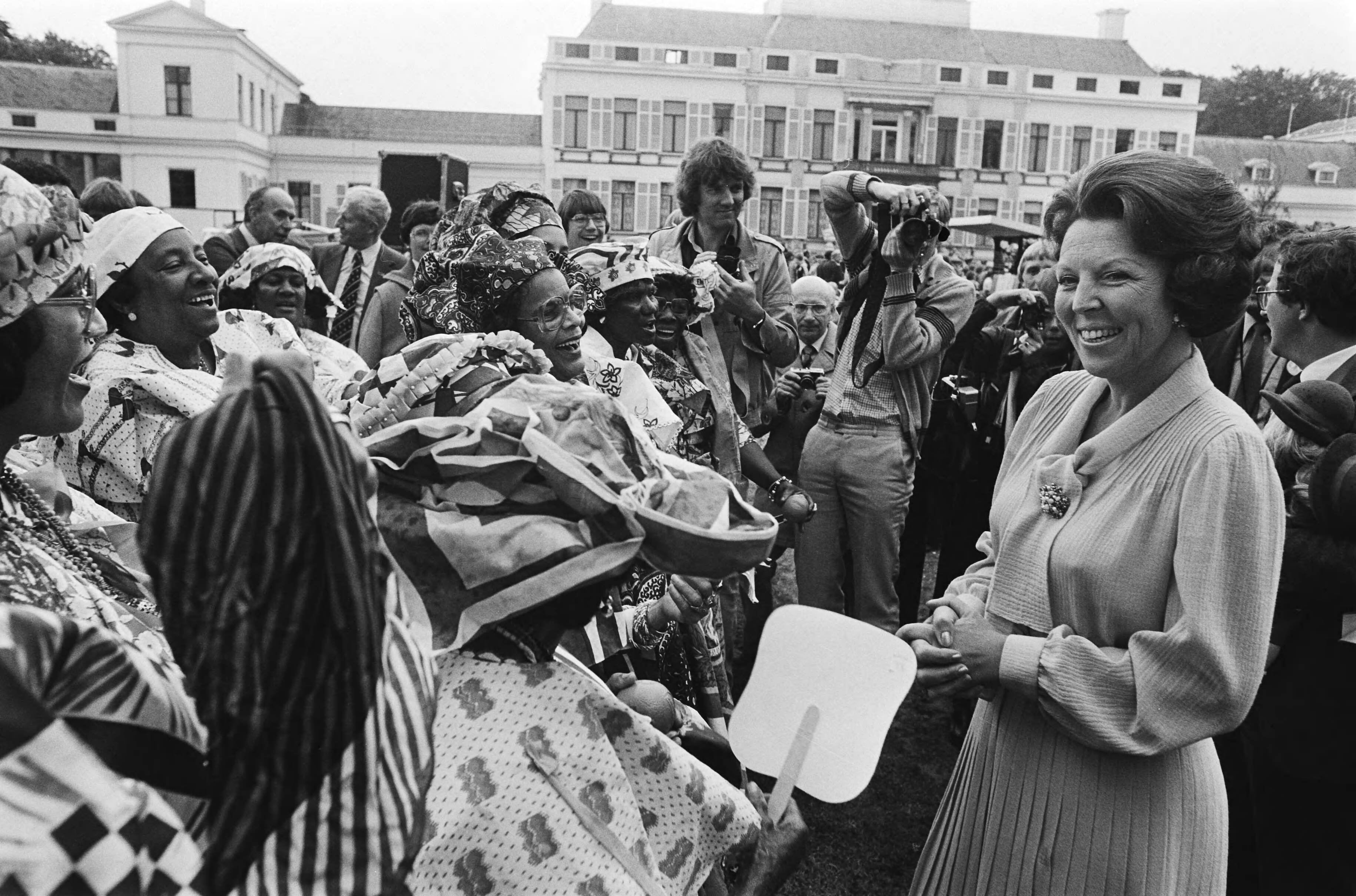 Koninginnedag 1980 — Laatste defilé op paleis Soestdijk; tijdens wandeling over het middenterrein; Koningin Beatrix in gesprek met Surinaamse vrouwen — Foto: Croes, Rob C. / Anefo. Licentie: Set B: Rechtenvrij / Publiek Domein. Bron: Nationaal Archief. http://hdl.handle.net/10648/ace191b4-d0b4-102d-bcf8-003048976d84