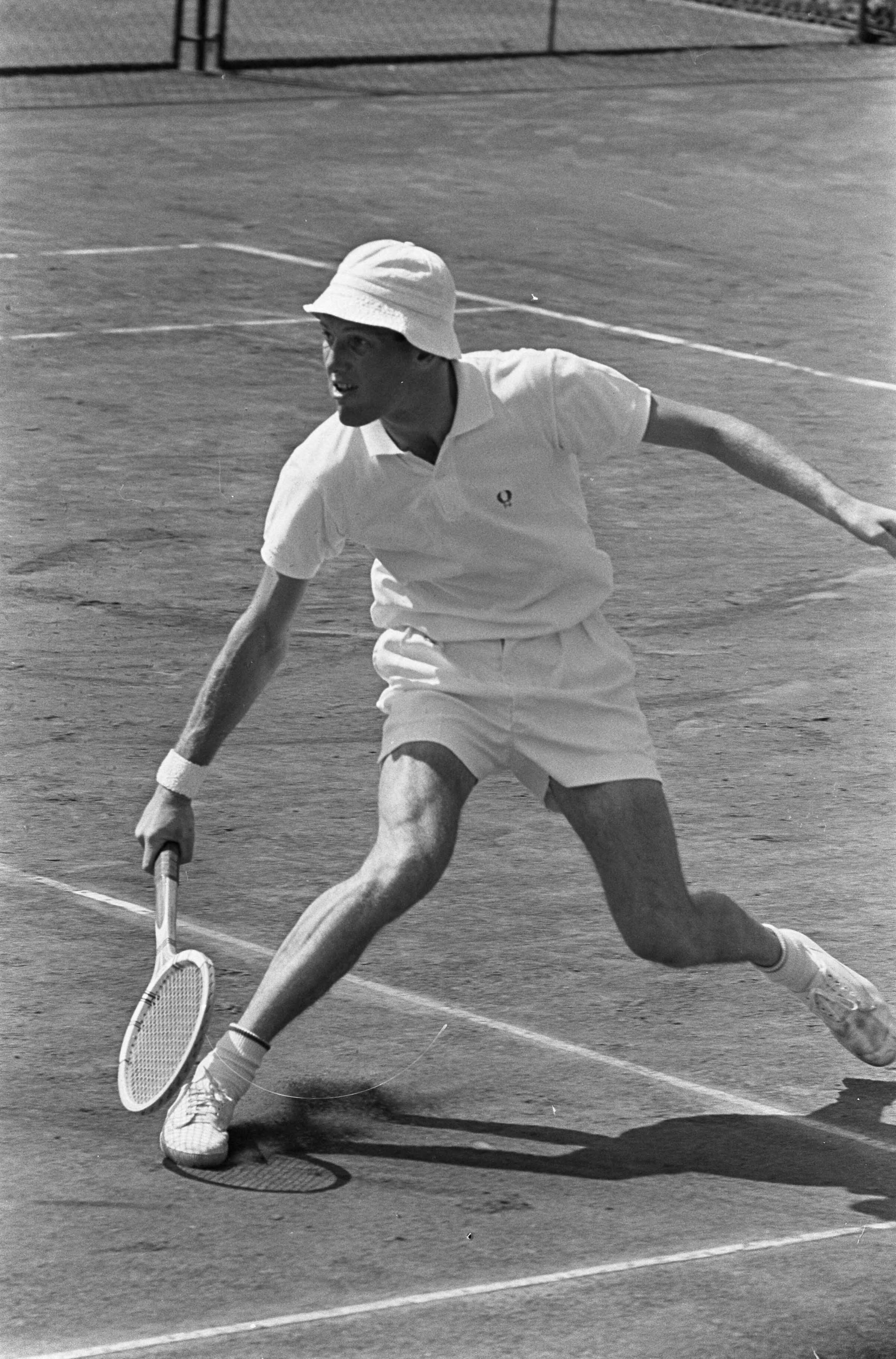 Fotocollectie Anefo — Nederlandse tenniskampioenschappen op de METS-banen. Tom Okker in actie (met pet op) — Foto: Koch, Eric / Anefo. Licentie: Set B: Rechtenvrij / Publiek Domein. Bron: Nationaal Archief. http://hdl.handle.net/10648/aaba8e72-d0b4-102d-bcf8-003048976d84