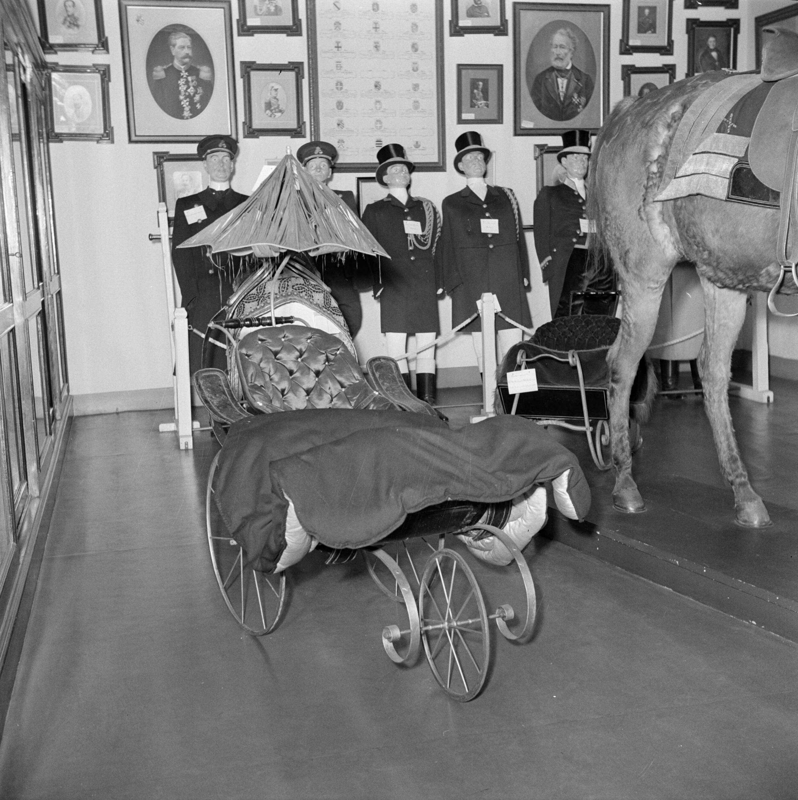 Troonsafstand koningin Wilhelmina / Inhuldiging van koningin Juliana — Voorbereidingen: een kijkje in het museum van het koninklijk staldepartement in Den Haag — Foto: Poll, Willem van de. Licentie: Set B: Rechtenvrij / Publiek Domein. Bron: Nationaal Archief. http://hdl.handle.net/10648/aee75962-d0b4-102d-bcf8-003048976d84