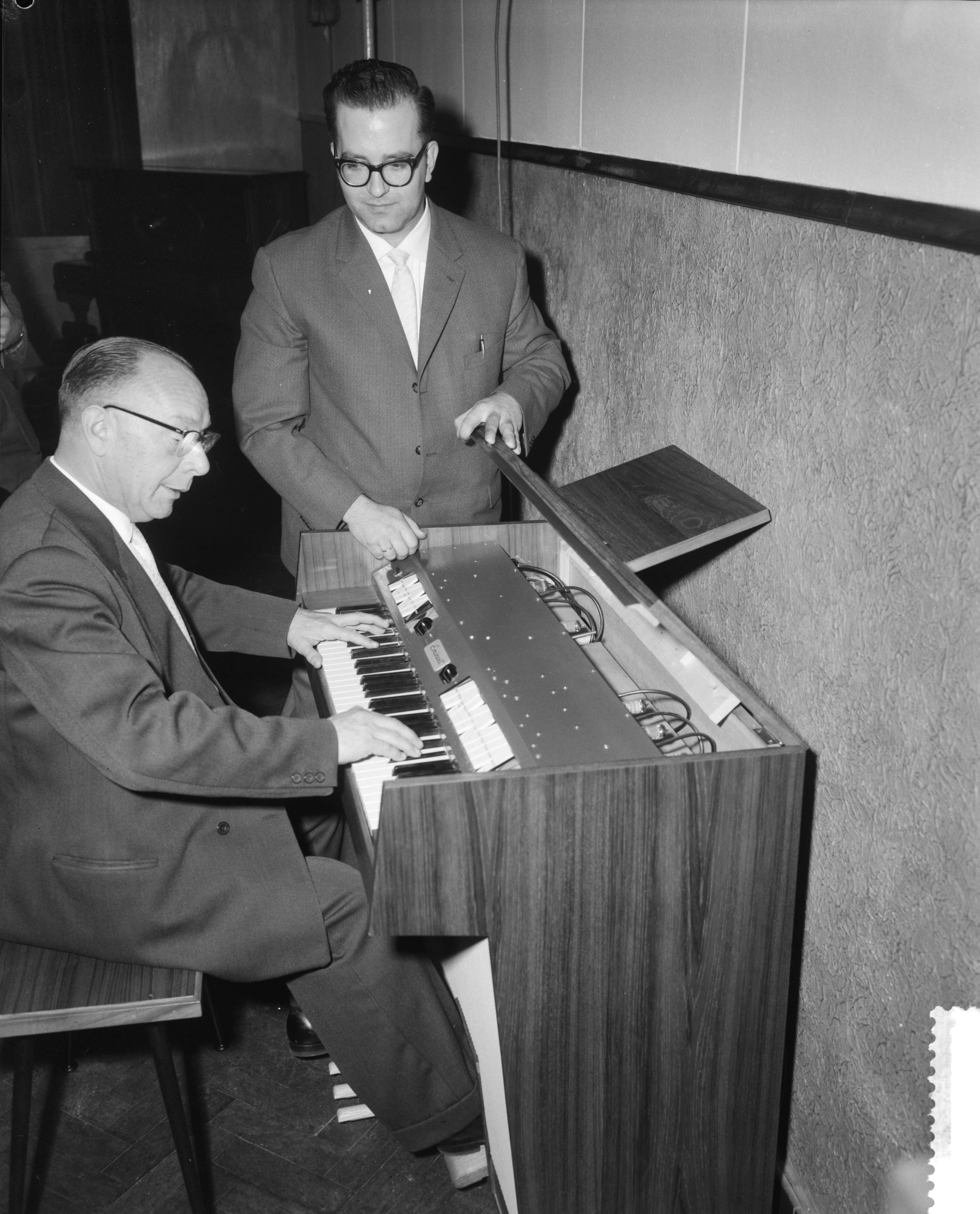Fotocollectie Anefo — Demonstratie van nieuw elektronisch huisorgel te Bodegraven. Ontwerper Hans Versteegt geeft toelichting, terwijl Pierre Palla speelt — Foto: Behrens, Herbert F. / Anefo. Licentie: Set B: Rechtenvrij / Publiek Domein. Bron: Nationaal Archief. http://hdl.handle.net/10648/a9c108ac-d0b4-102d-bcf8-003048976d84