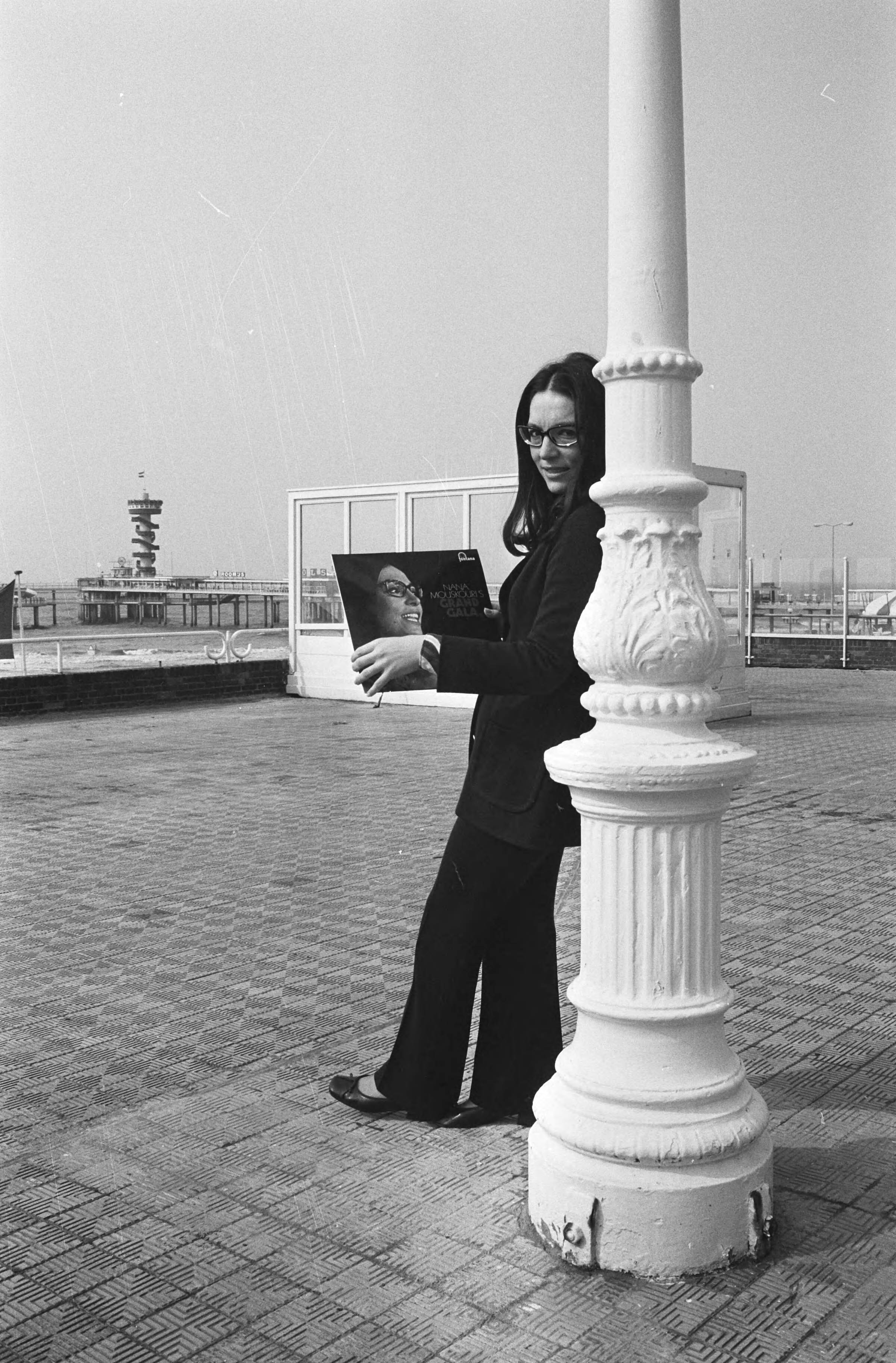 Nana Mouskouri krijgt een gouden en een platina plaat in het Kurhaus te — Nana Mouskouri toont haar platen — Foto: Fotograaf Onbekend / Anefo. Licentie: Set B: Rechtenvrij / Publiek Domein. Bron: Nationaal Archief. http://hdl.handle.net/10648/abbf474a-d0b4-102d-bcf8-003048976d84