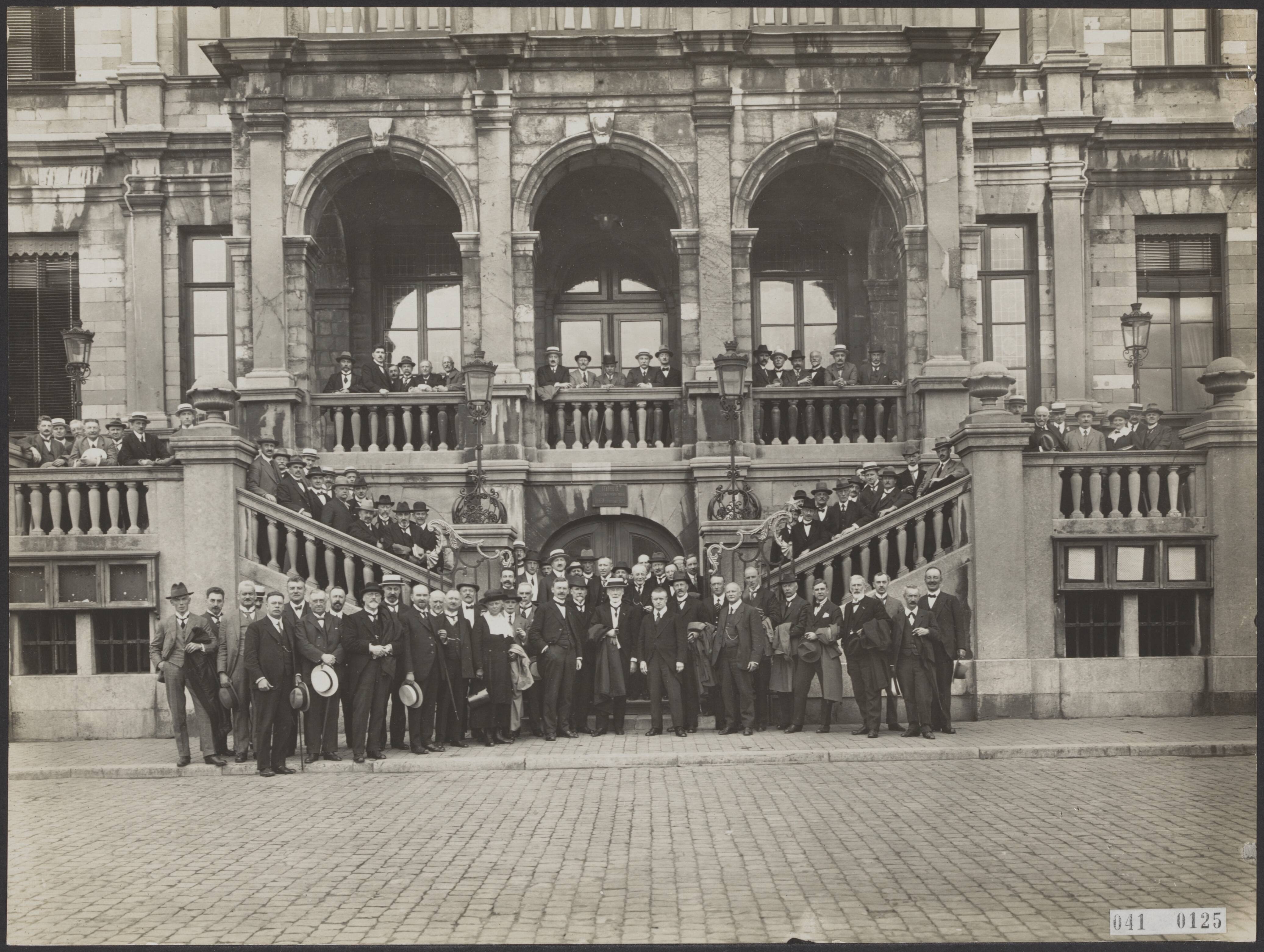 Fotocollectie Elsevier Binnenland — Bijeenkomst van de Algemene Vergadering van de Koninklijke Nederlandse Maatschappij tot Bevordering van de Geneeskunst in Maastricht. Groepsportret op de trappen van het stadhuis. In het midden met jas over de arm de voorzitter, links van hem mr. van Oppen, burgemeester van Maastricht — Foto: Fotopersbureau "Holland". Licentie: Set B: Rechtenvrij / Publiek Domein. Bron: Nationaal Archief. http://hdl.handle.net/10648/adf5f982-d0b4-102d-bcf8-003048976d84