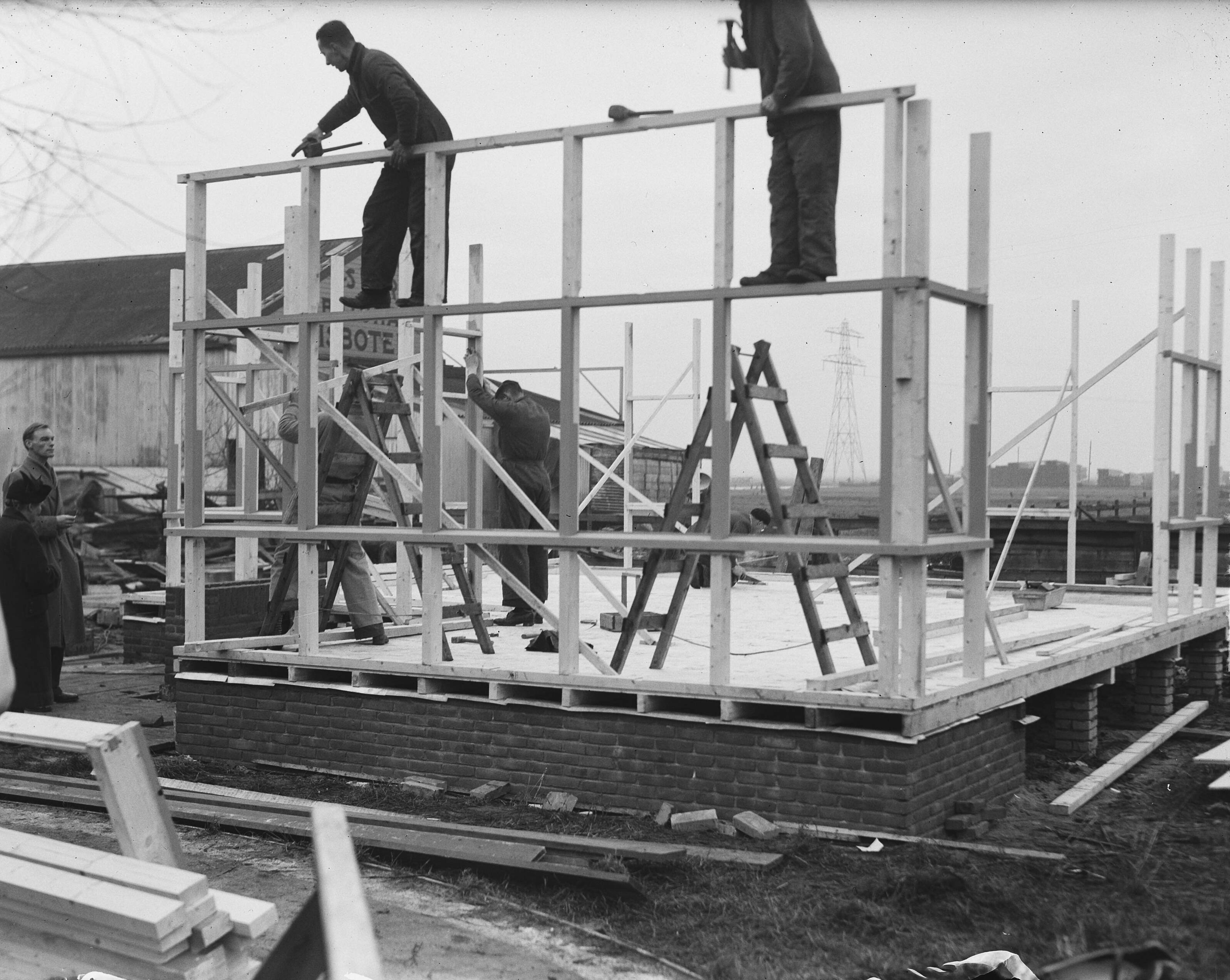 Fotocollectie Anefo — Demonstratie van een bouwpakket "emigrantenwoning" door een aannemingsbedrijf in Zaandam. De woning is bedoeld voor emigranten naar o.a. Australië en kan in een dag opgebouwd worden — Foto: Oorschot, […] van / Anefo. Licentie: Set B: Rechtenvrij / Publiek Domein. Bron: Nationaal Archief. http://hdl.handle.net/10648/a8e60360-d0b4-102d-bcf8-003048976d84