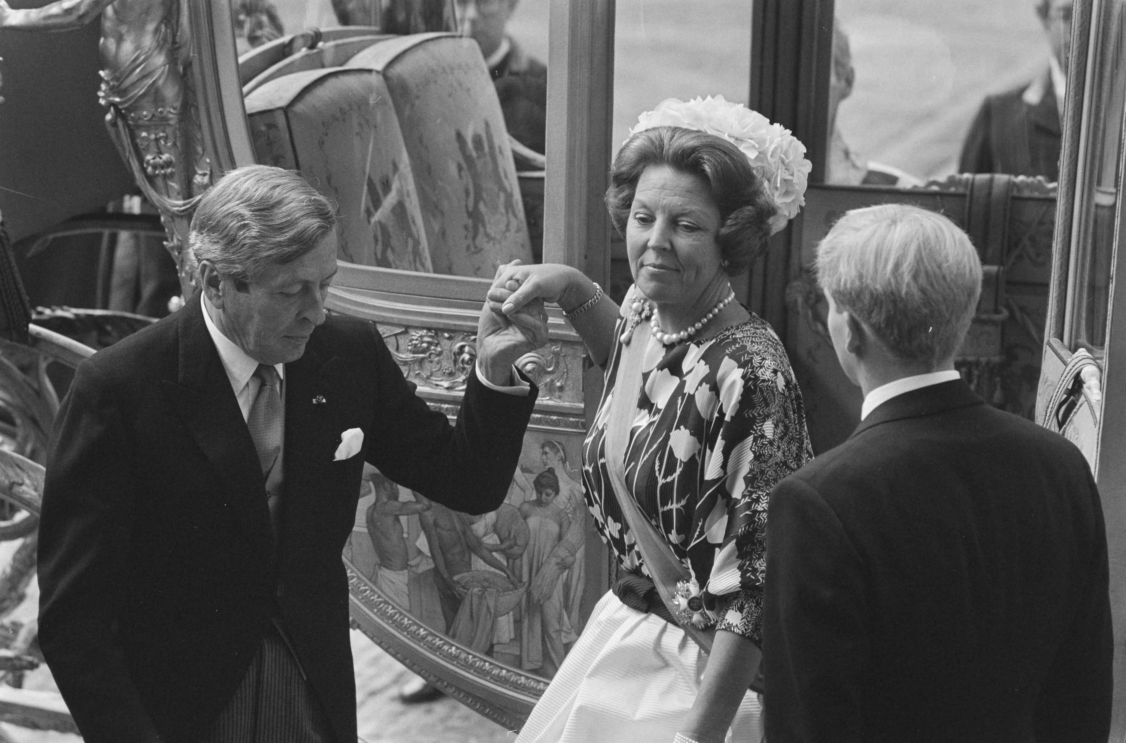 Fotocollectie Anefo — Prinsjesdag 1987, Den Haag ; Koningin Beatrix wordt uit Goeden Koets geholpen door Prins Claus — Foto: Bogaerts, Rob / Anefo. Licentie: Set B: Rechtenvrij / Publiek Domein. Bron: Nationaal Archief. http://hdl.handle.net/10648/ad640aea-d0b4-102d-bcf8-003048976d84