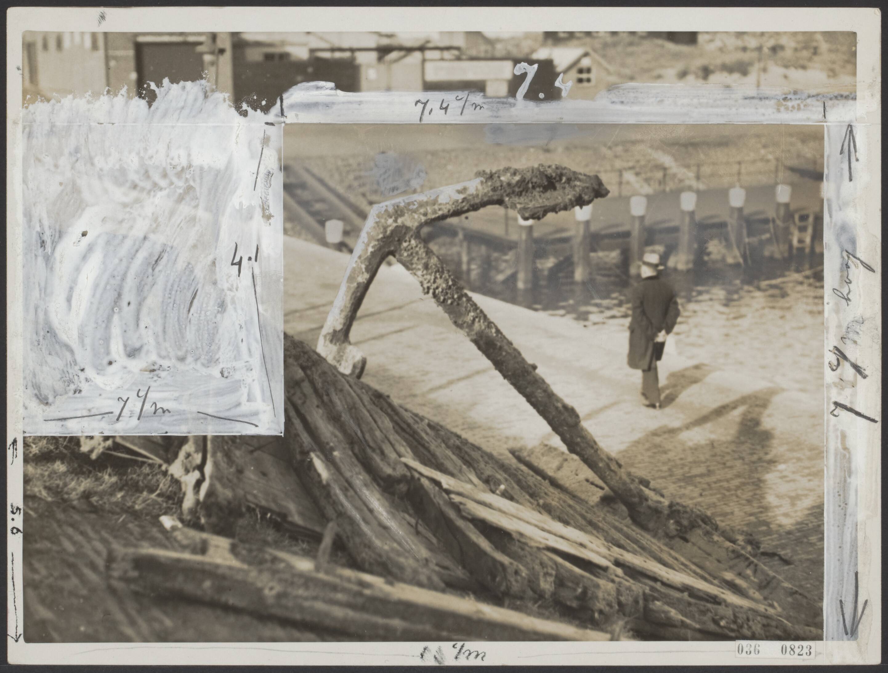 Fotocollectie Elsevier Binnenland — "Een gewichtige vangst" . Door de UK. 170 werd in haar net opgevist 5 meter groot anker binnen gebracht. Men kan nog niet bepalen van welk schip dit afkomstig is. Wel staat vast dat het enige eeuwen oud is en afkomstig van een zeilschip. Het anker is voorlopig bij de haven gedeponeerd bij een wrak dat indertijd al binnen is gebracht. Het anker en houten scheepsgedeelte van boven af gezien. — Foto: N.V. Polygoon. Licentie: Set B: Rechtenvrij / Publiek Domein. Bron: Nationaal Archief. http://hdl.handle.net/10648/adecf4ea-d0b4-102d-bcf8-003048976d84