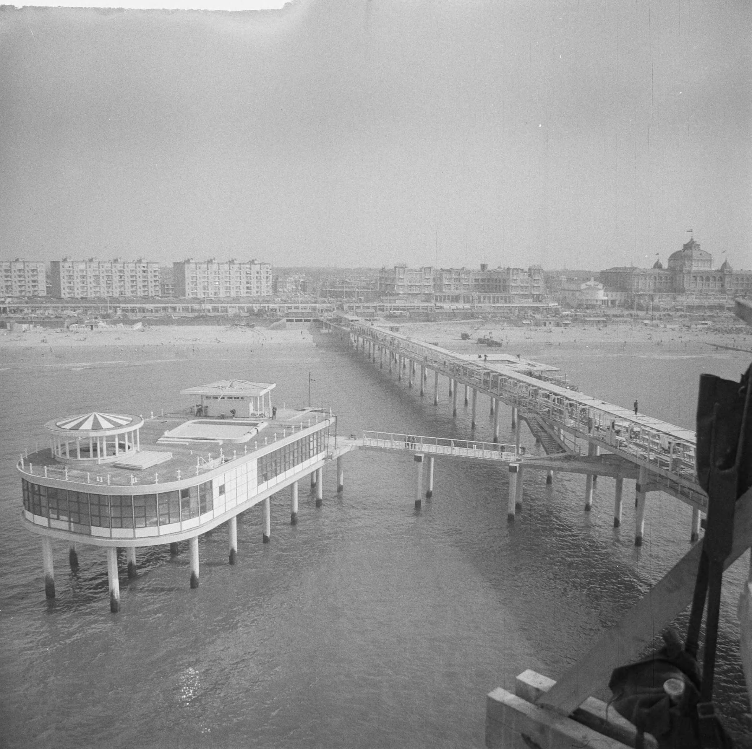 Fotocollectie Anefo — Werkzaamheden Pier te Scheveningen. Overzicht Pier naar het strand — Foto: Nijs, Jac. de / Anefo. Licentie: Set B: Rechtenvrij / Publiek Domein. Bron: Nationaal Archief. http://hdl.handle.net/10648/a9d0f6ea-d0b4-102d-bcf8-003048976d84
