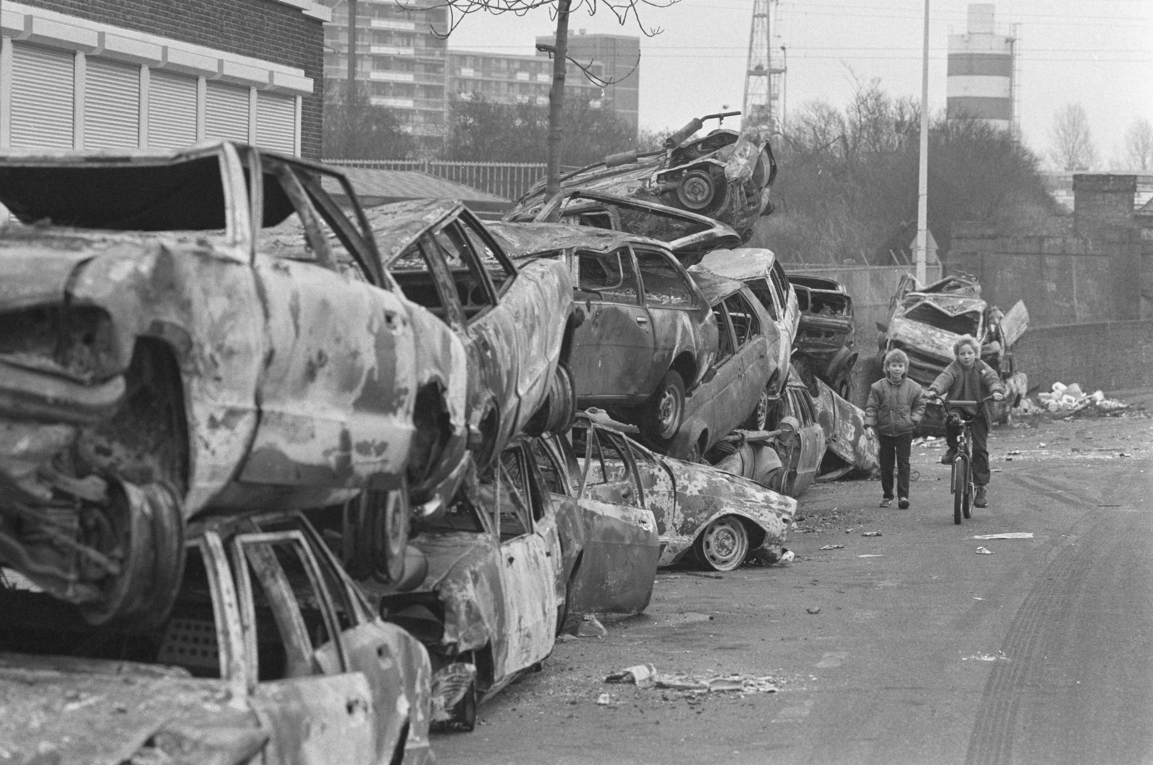 Uitgebrande auto's in Den Haag na oudejaarsnacht — Lopend en fietsend kind — Foto: Bogaerts, Rob / Anefo. Licentie: Set B: Rechtenvrij / Publiek Domein. Bron: Nationaal Archief. http://hdl.handle.net/10648/ad6f84ce-d0b4-102d-bcf8-003048976d84