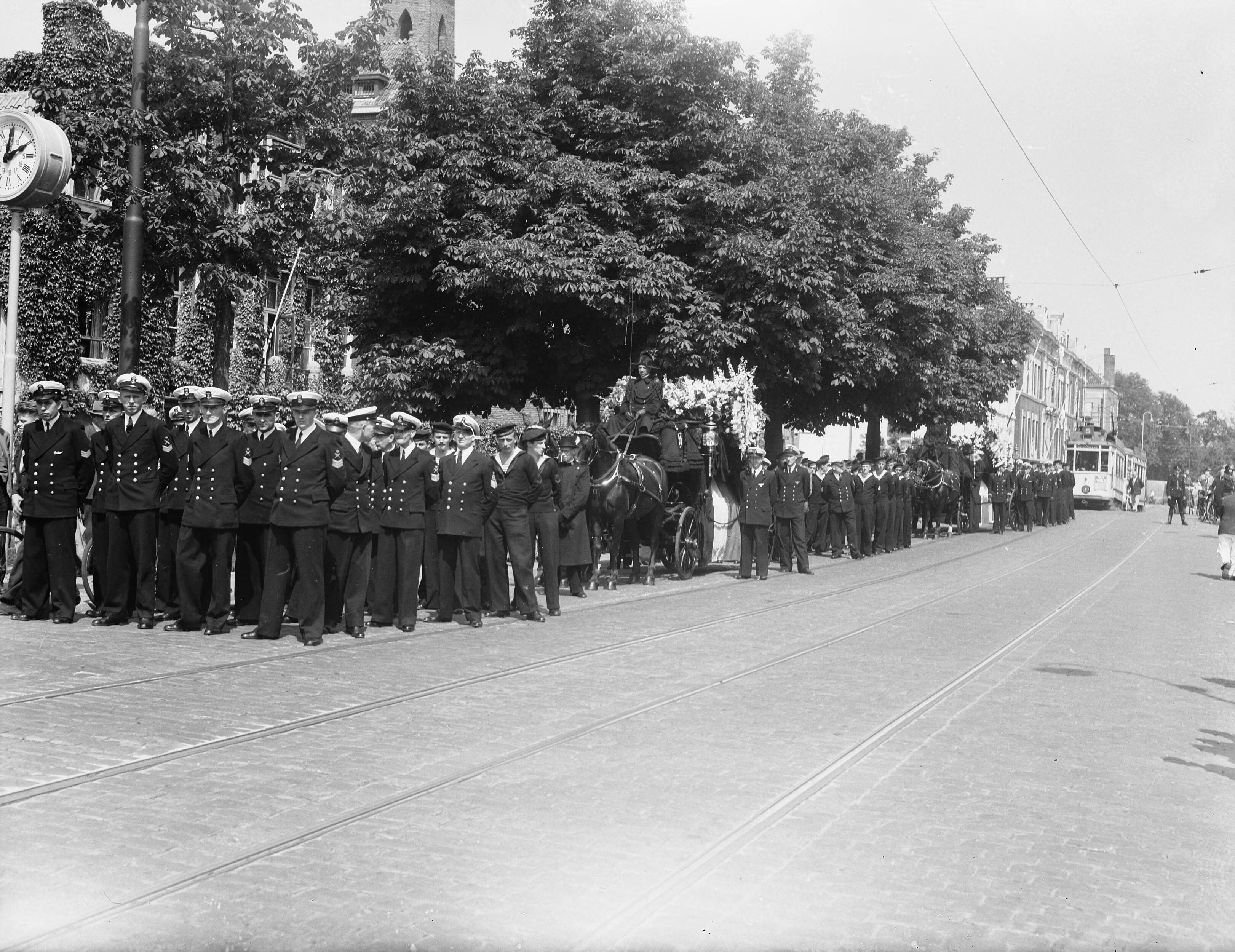Fotocollectie Anefo — Begrafenis van 3 marine-officieren in Den Haag. Stoet onderweg — Foto: Merk, Ben / Anefo. Licentie: Set B: Rechtenvrij / Publiek Domein. Bron: Nationaal Archief. http://hdl.handle.net/10648/a8ba4ad6-d0b4-102d-bcf8-003048976d84