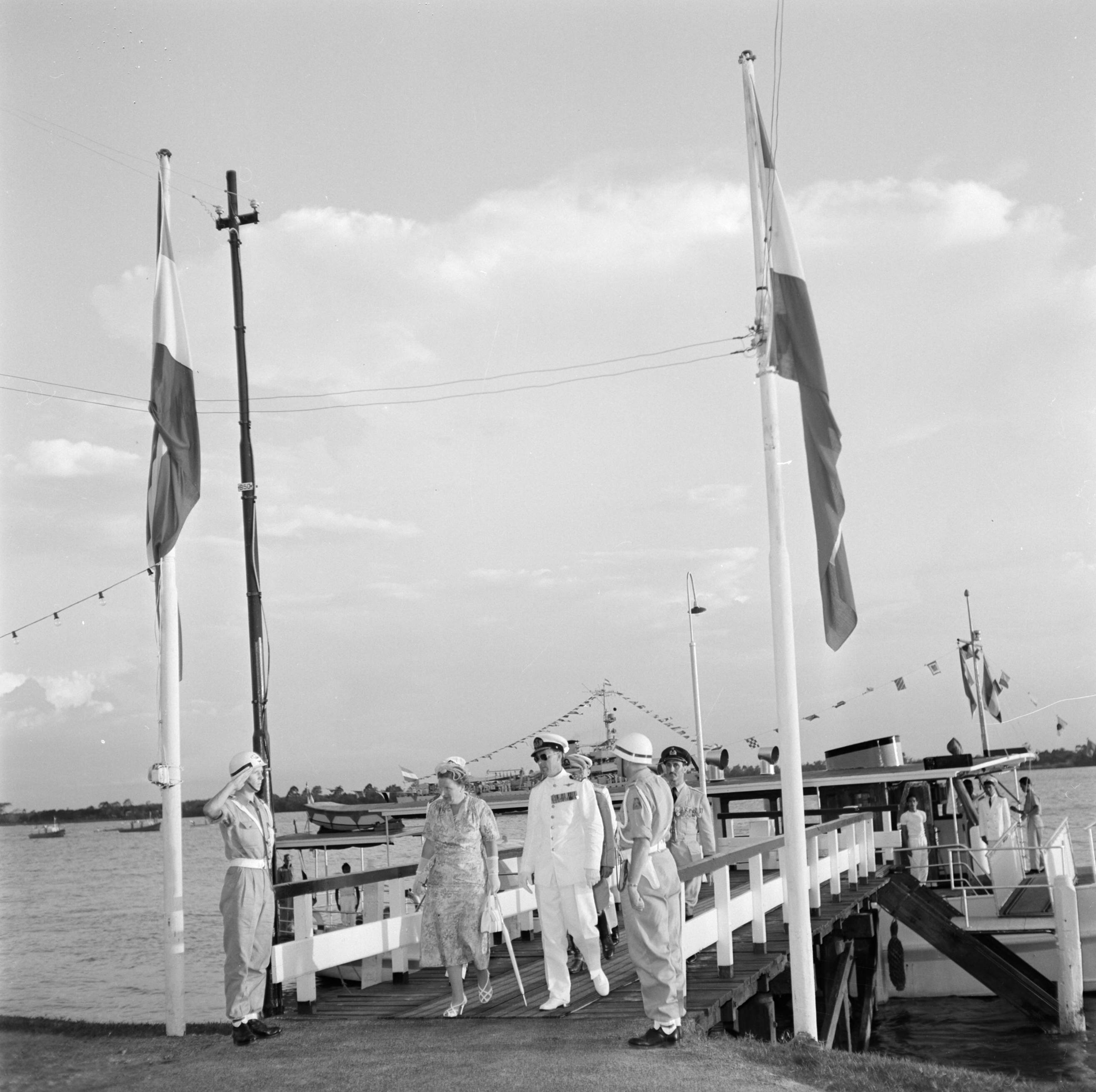 Nederlandse Antillen en Suriname ten tijde van het koninklijk bezoek van koningin Juliana en prins Bernhard in 1955 — Het koninklijk paar op de aanlegsteiger bij Domburg — Foto: Poll, Willem van de. Licentie: Set B: Rechtenvrij / Publiek Domein. Bron: Nationaal Archief. http://hdl.handle.net/10648/aeb26d42-d0b4-102d-bcf8-003048976d84