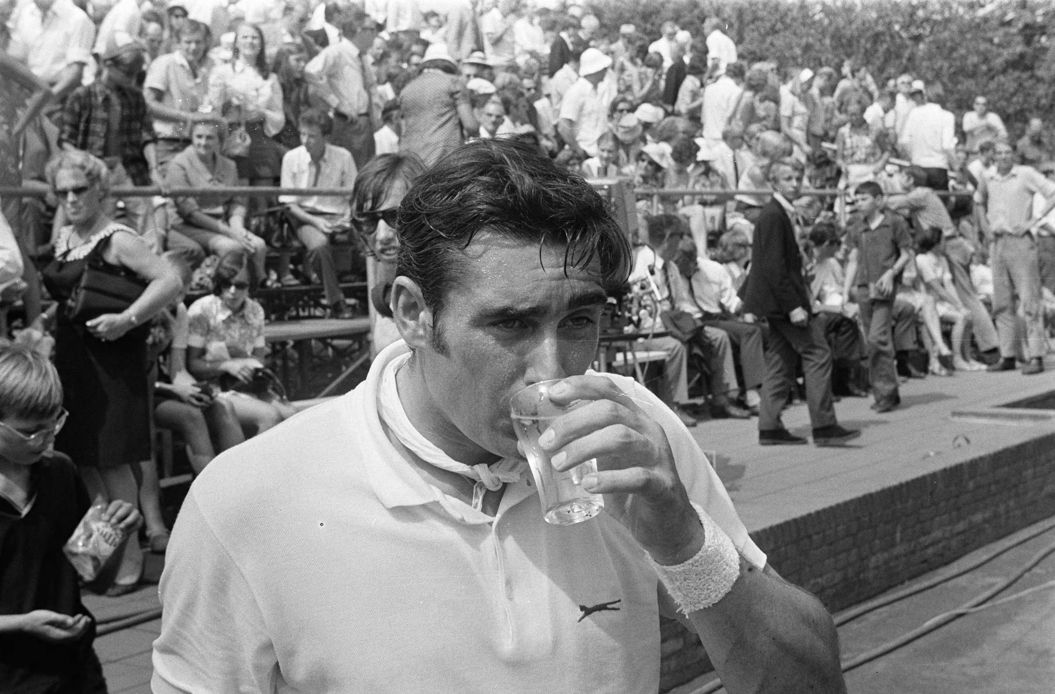 Open Nederlandse Tenniskampioenschappen 1969 in Hilversum — Roger Taylor (Engeland) drinkt een glas water — Foto: Fotograaf Onbekend / Anefo. Licentie: Set B: Rechtenvrij / Publiek Domein. Bron: Nationaal Archief. http://hdl.handle.net/10648/ab74f992-d0b4-102d-bcf8-003048976d84
