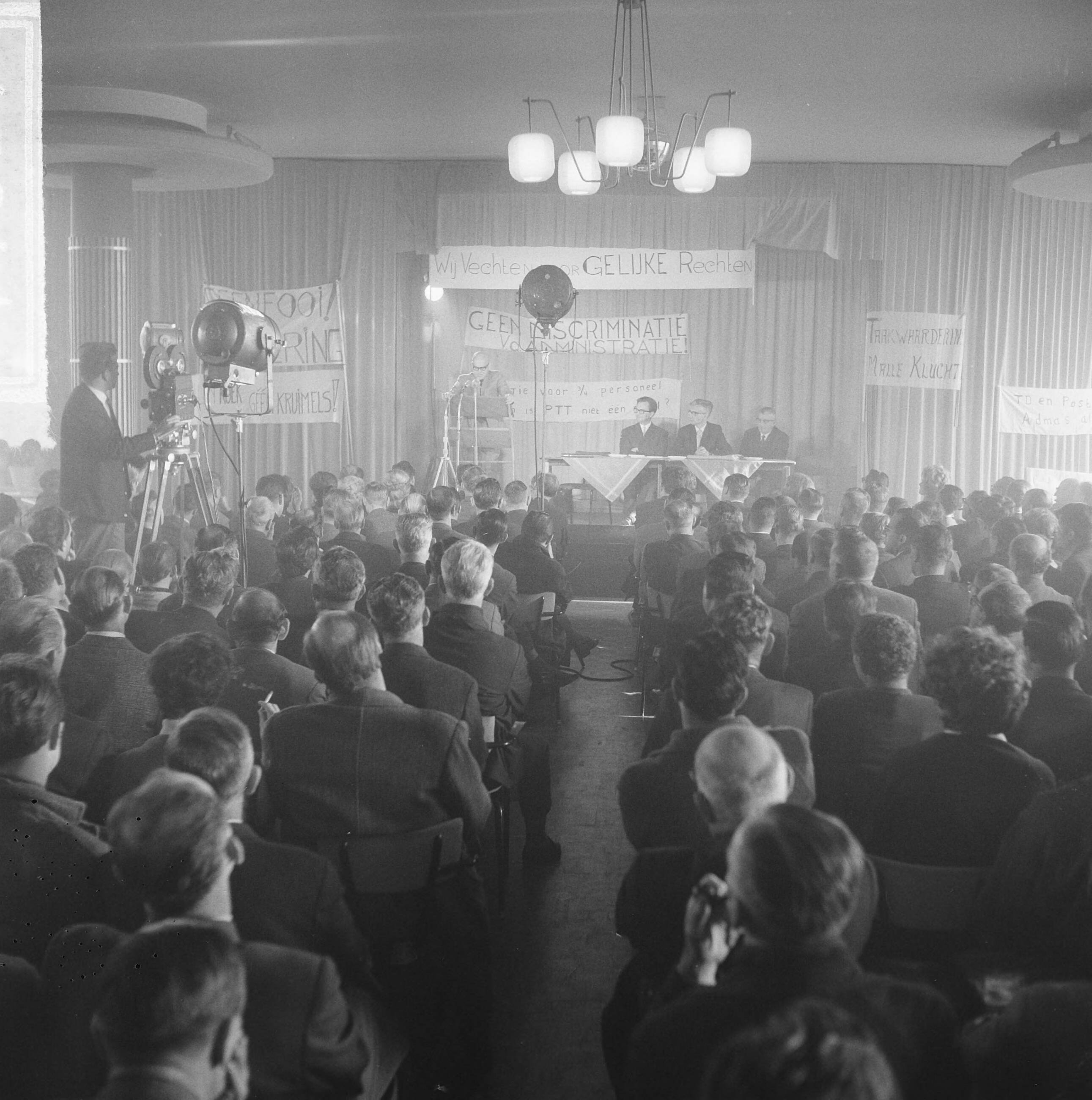 Fotocollectie Anefo — 500 PTT-ers protesteren tegen personeels- en promotiebeleid bij PTT in het Houtrustrestaurant te Den Haag — Foto: Gelderen, Hugo van / Anefo. Licentie: Set B: Rechtenvrij / Publiek Domein. Bron: Nationaal Archief. http://hdl.handle.net/10648/aa8218da-d0b4-102d-bcf8-003048976d84