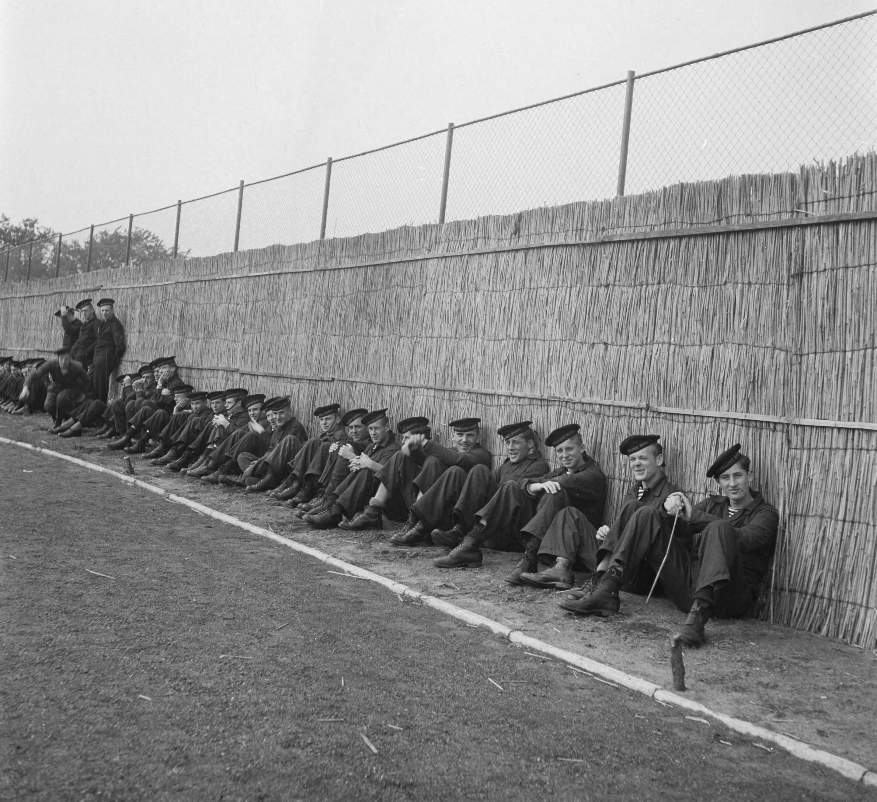 MOK Hilversum 1948 — MOK Hilversum. Matrozen tegen rieten achtergrond — Foto: Steenkamp, B.J.J. (Ben) / Anefo. Licentie: Set B: Rechtenvrij / Publiek Domein. Bron: Nationaal Archief. http://hdl.handle.net/10648/a8bd990c-d0b4-102d-bcf8-003048976d84