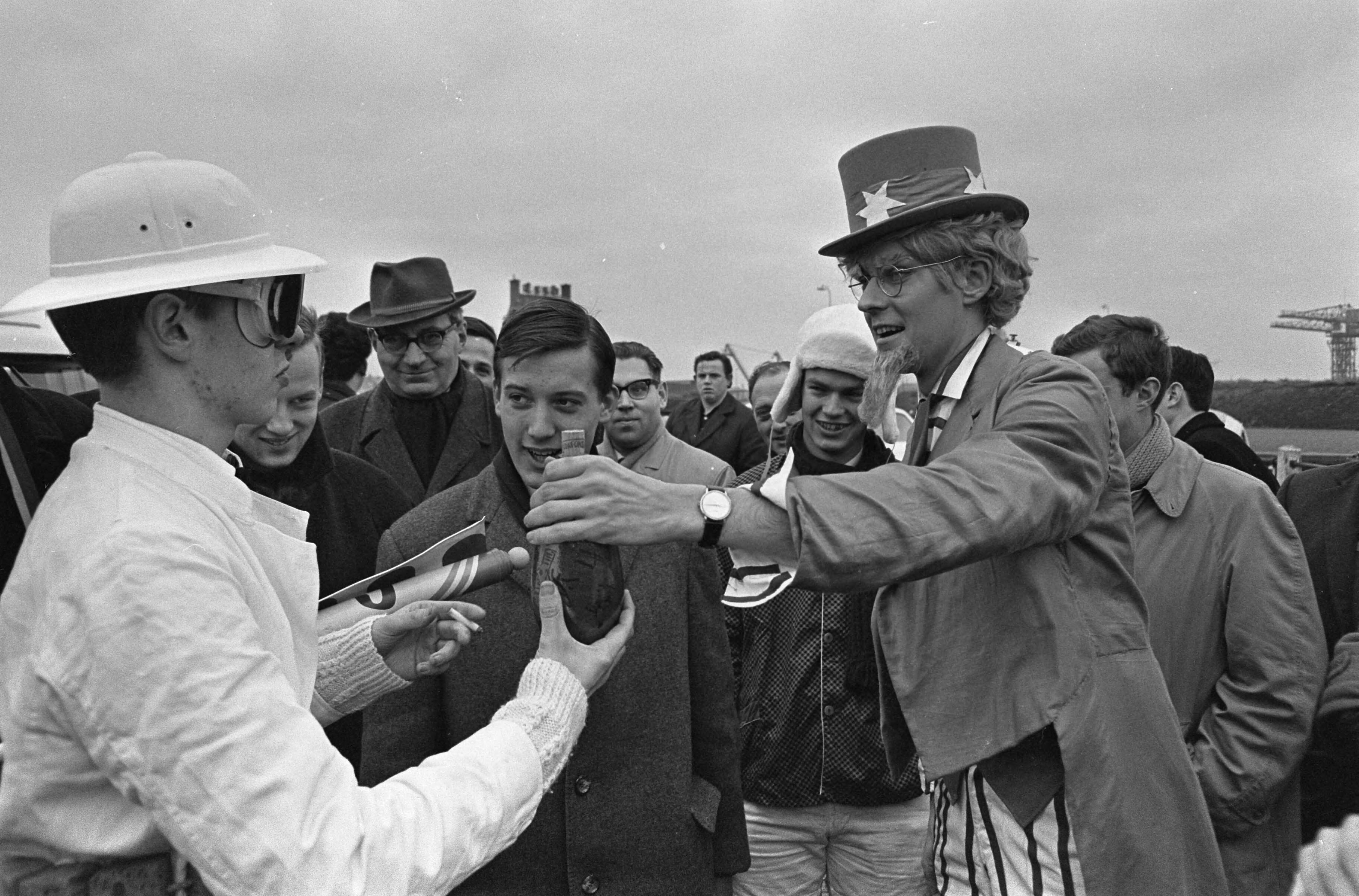 Fotocollectie Anefo — Kruik boegwater van radioschip Veronica, op autopeds als estafette van de buitenhaven van Scheveningen naar Utrecht gebracht door leden van het Utrechts Studenten Corps, de kruik (van Egypische makelij) wordt overhandigd door Uncle Sam — Foto: Kroon, Ron / Anefo. Licentie: Set B: Rechtenvrij / Publiek Domein. Bron: Nationaal Archief. http://hdl.handle.net/10648/aad9eda8-d0b4-102d-bcf8-003048976d84