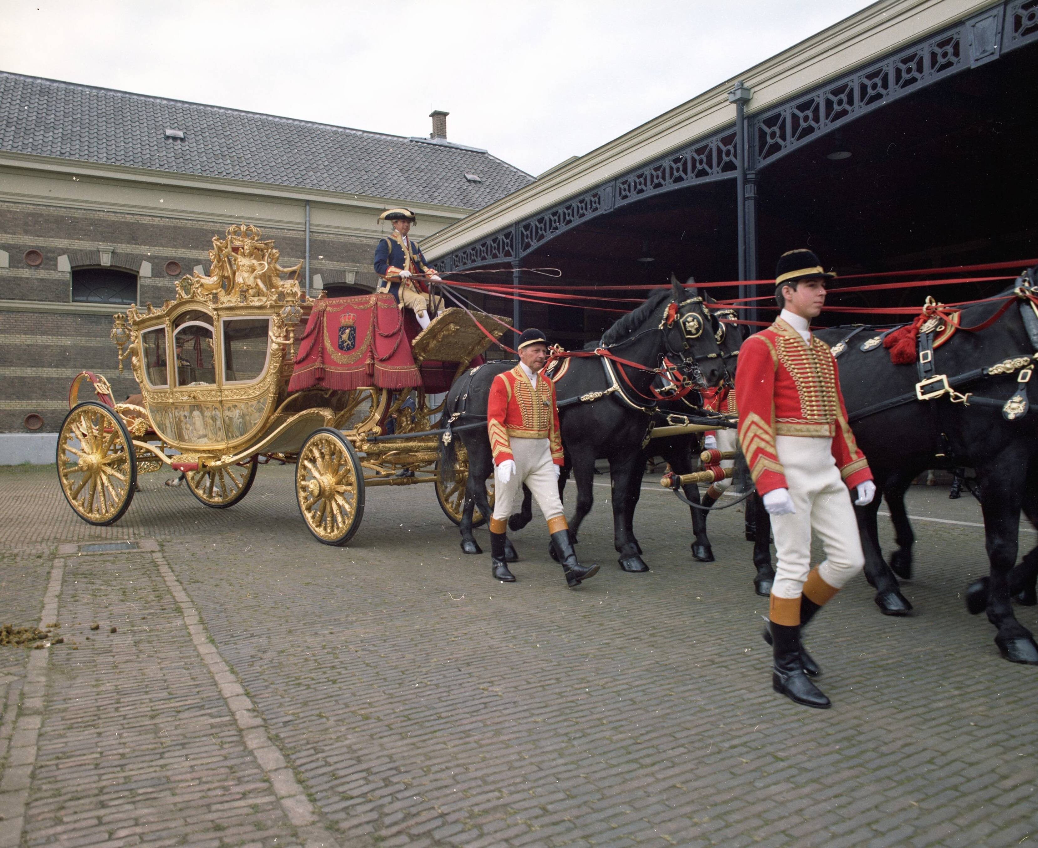 Fotocollectie RVD / Koninklijk Huis — Gouden koets met koetsier, stalpersoneel en paarden op de binnenplaats van de koninklijke stallen aan de Noordwal in Den Haag — Foto: Mastenbroek, Cees / RVD. Licentie: Set B: Rechtenvrij / Publiek Domein. Bron: Nationaal Archief. http://hdl.handle.net/10648/afb27c5a-d0b4-102d-bcf8-003048976d84