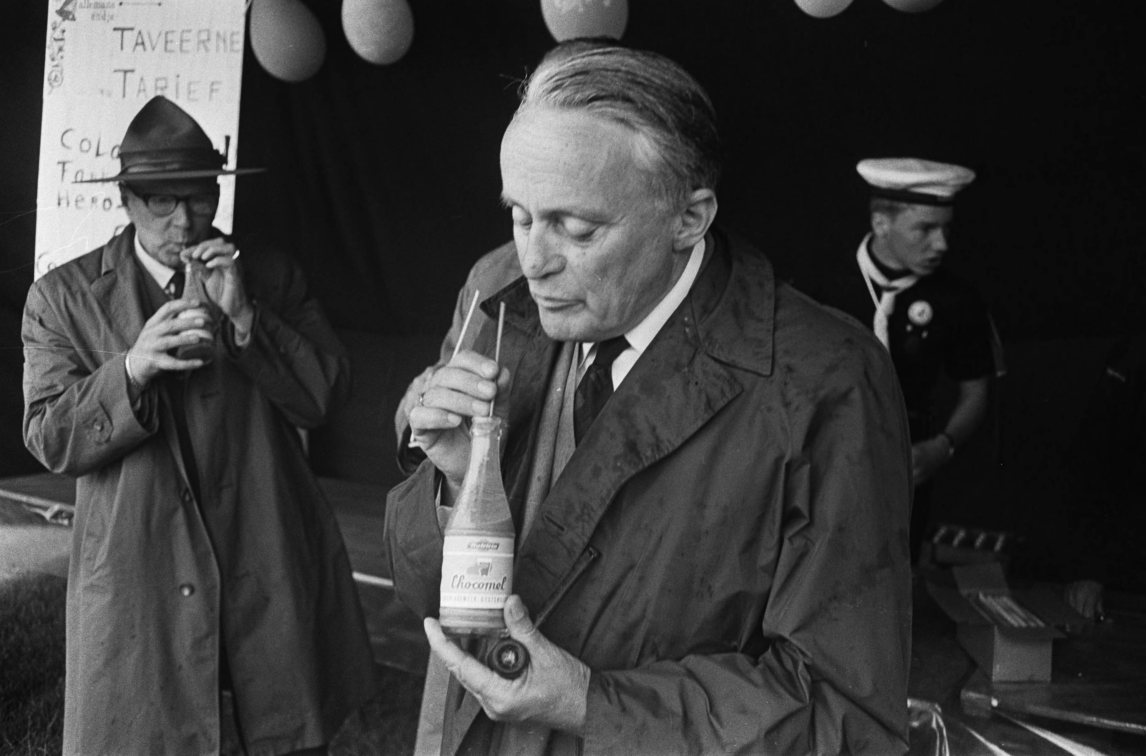 Fotocollectie Anefo — Nationaal Waterkamp in Nieuwkoop door de Commissaris van de Koningin in Zuid-Holland, mr. J. Klaasesz, geopend. J. Klaasesz drinkt chocolademelk uit een flesje — Foto: Koch, Eric / Anefo. Licentie: Set B: Rechtenvrij / Publiek Domein. Bron: Nationaal Archief. http://hdl.handle.net/10648/aab77afc-d0b4-102d-bcf8-003048976d84