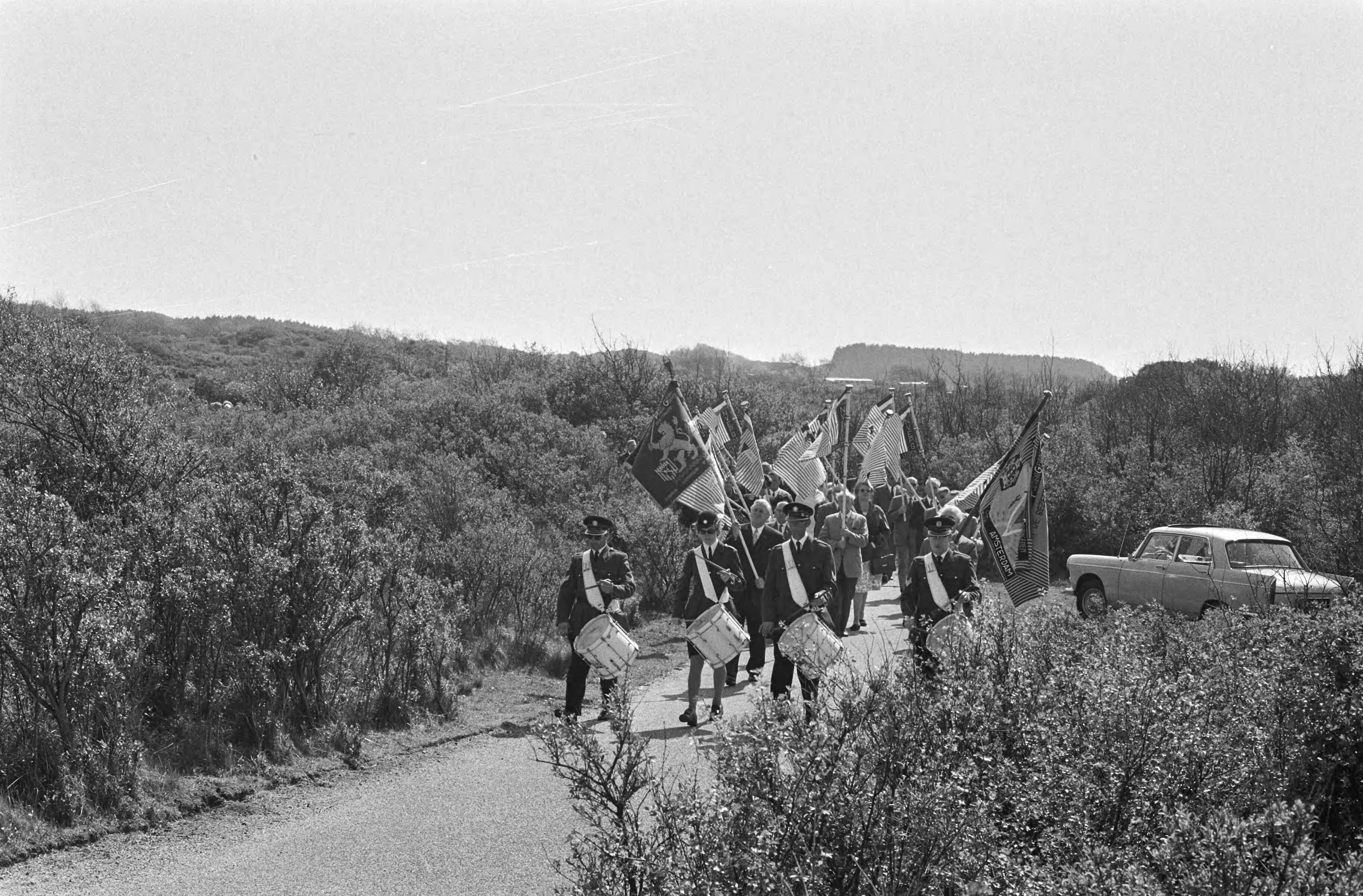 Jaarlijkse herdenking van 1940-1945 op de erebegraafplaats te Overveen — Stille tocht naar de erebegraafplaats voorafgegaan door de Koninklijke Militaire Kapel — Foto: Fotograaf Onbekend / Anefo. Licentie: Set B: Rechtenvrij / Publiek Domein. Bron: Nationaal Archief. http://hdl.handle.net/10648/abbe9e76-d0b4-102d-bcf8-003048976d84