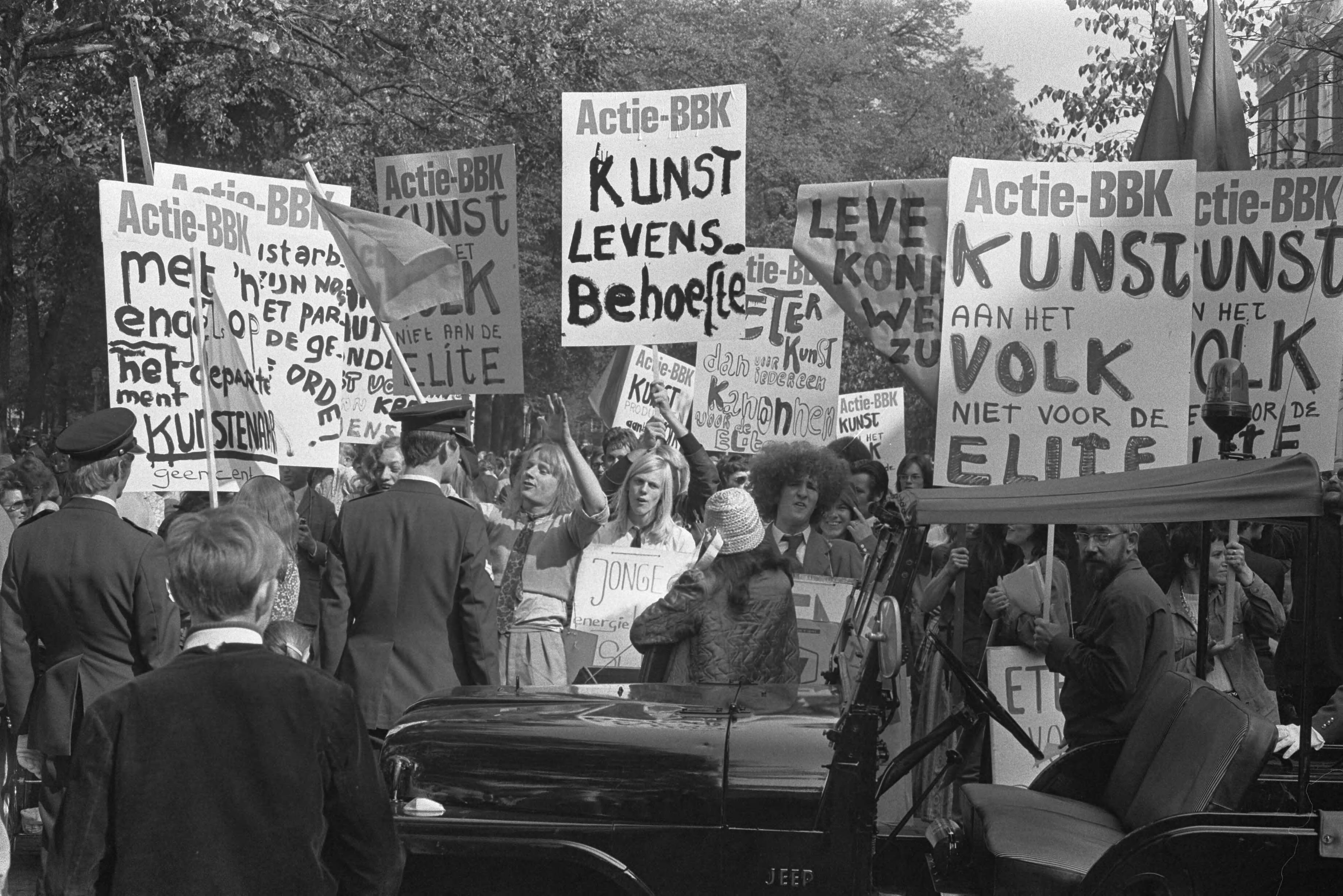 Fotocollectie Anefo — BBK ( Beroepsvereniging Beeldende Kunstenaars ), leden met protestborden langs route Gouden Koets , Den Haag — Foto: Verhoeff, Bert / Anefo. Licentie: Set B: Rechtenvrij / Publiek Domein. Bron: Nationaal Archief. http://hdl.handle.net/10648/abcfb49a-d0b4-102d-bcf8-003048976d84