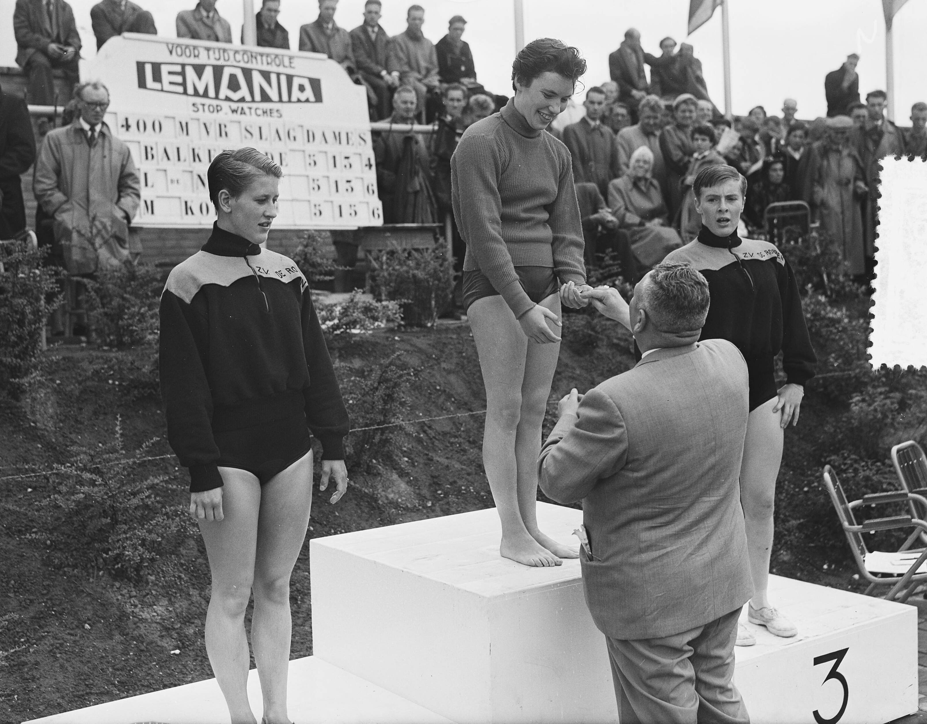 Fotocollectie Anefo — Nederlandse kampioenschappen zwemmen te Groningen, Huldiging 400 m vrije slag dames. Winnares Hetty Balkenende wordt gefeliciteerd. Links Leny de Nijs (2e) en rechts Mary Kok (3e) — Foto: Bilsen, Joop van / Anefo. Licentie: Set B: Rechtenvrij / Publiek Domein. Bron: Nationaal Archief. http://hdl.handle.net/10648/a9393eb8-d0b4-102d-bcf8-003048976d84