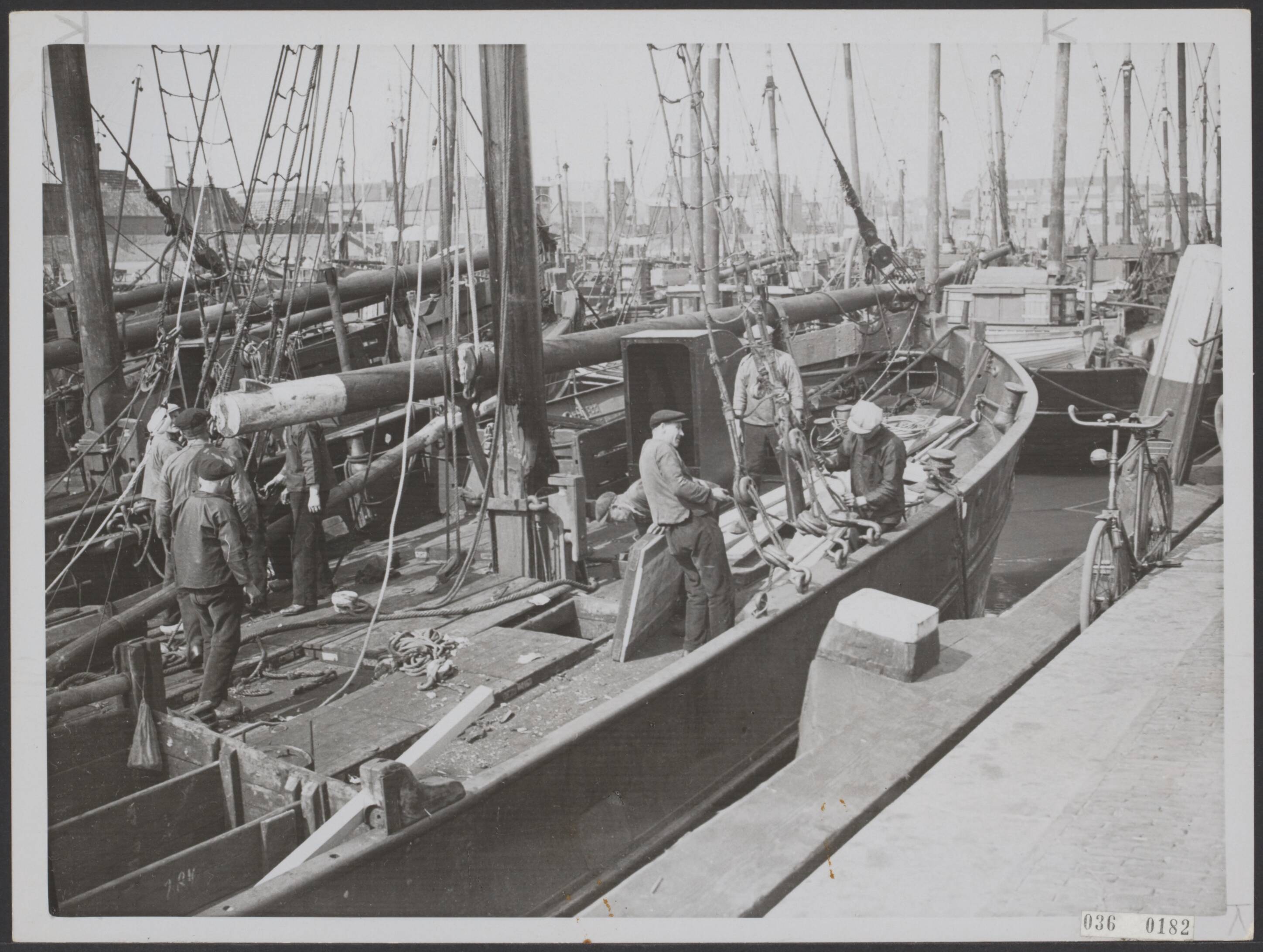 Fotocollectie Elsevier Binnenland — Op maandag 12 mei 1936 zullen de eerste Scheveningse schepen naar de haringvisserij vertrekken. De bemanning is met man en macht begonnen met het optuigen der schepen — Foto: N.V. Polygoon. Licentie: Set B: Rechtenvrij / Publiek Domein. Bron: Nationaal Archief. http://hdl.handle.net/10648/adec0b98-d0b4-102d-bcf8-003048976d84