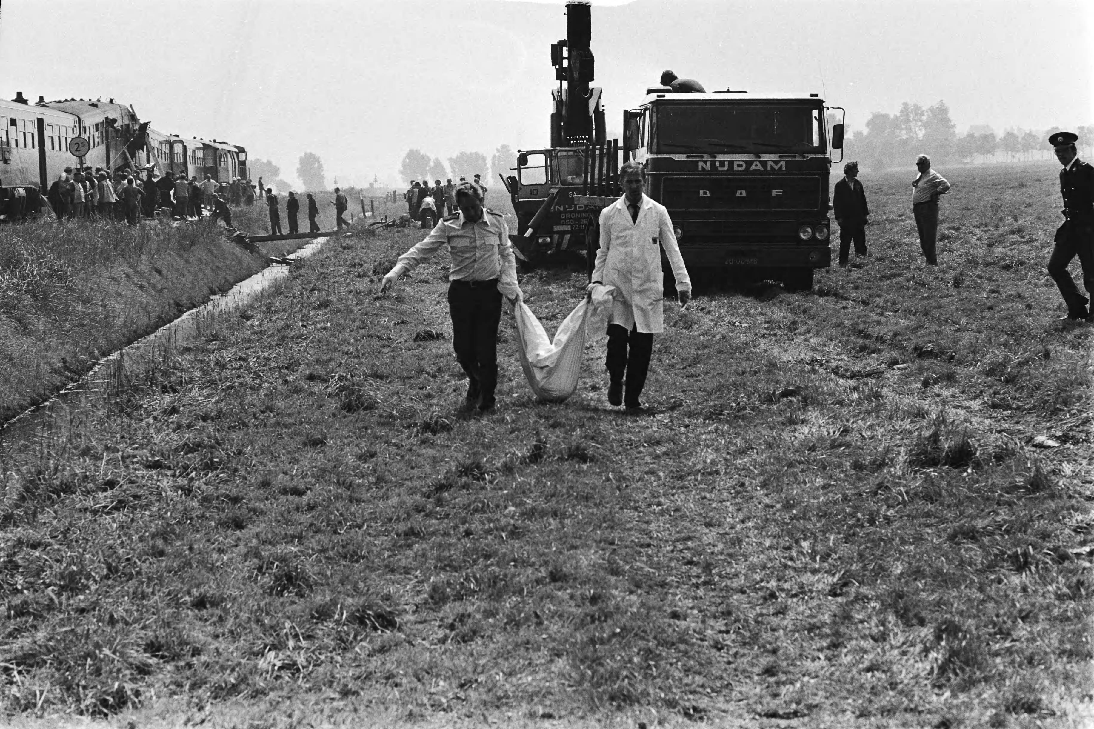 Treinramp Sauwerd — Het wegdragen van een slachtoffer — Foto: Pereira, Fernando / Anefo. Licentie: Set B: Rechtenvrij / Publiek Domein. Bron: Nationaal Archief. http://hdl.handle.net/10648/ace4927e-d0b4-102d-bcf8-003048976d84