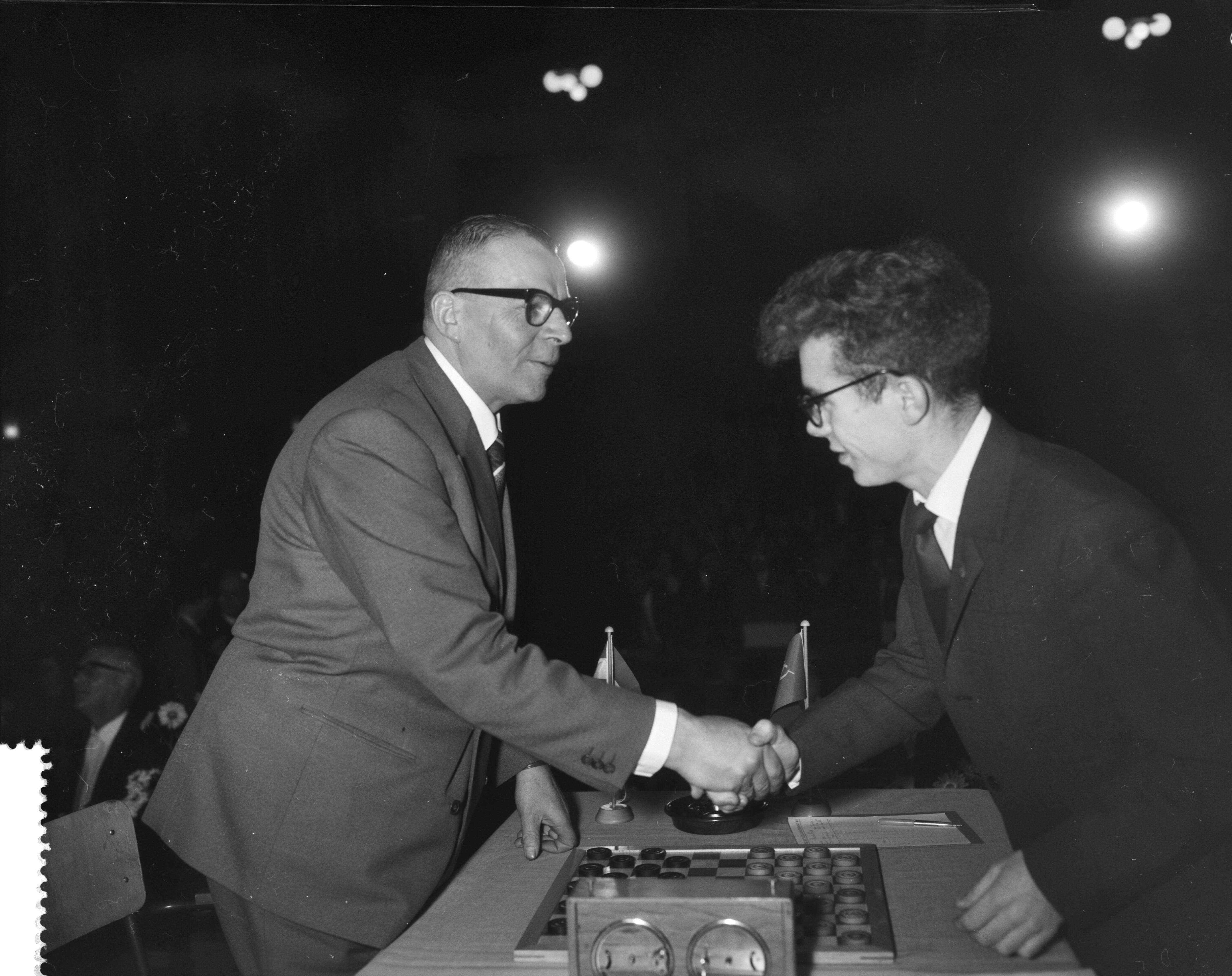 Fotocollectie Anefo — Laatste ronde wereldkampioenschap dammen in het Concertgebouw te Haarlem. Baris Dukel feliciteert wereldkampioen Tsjegolev (rechts) — Foto: Bilsen, Joop van / Anefo. Licentie: Set B: Rechtenvrij / Publiek Domein. Bron: Nationaal Archief. http://hdl.handle.net/10648/a9bf3fea-d0b4-102d-bcf8-003048976d84