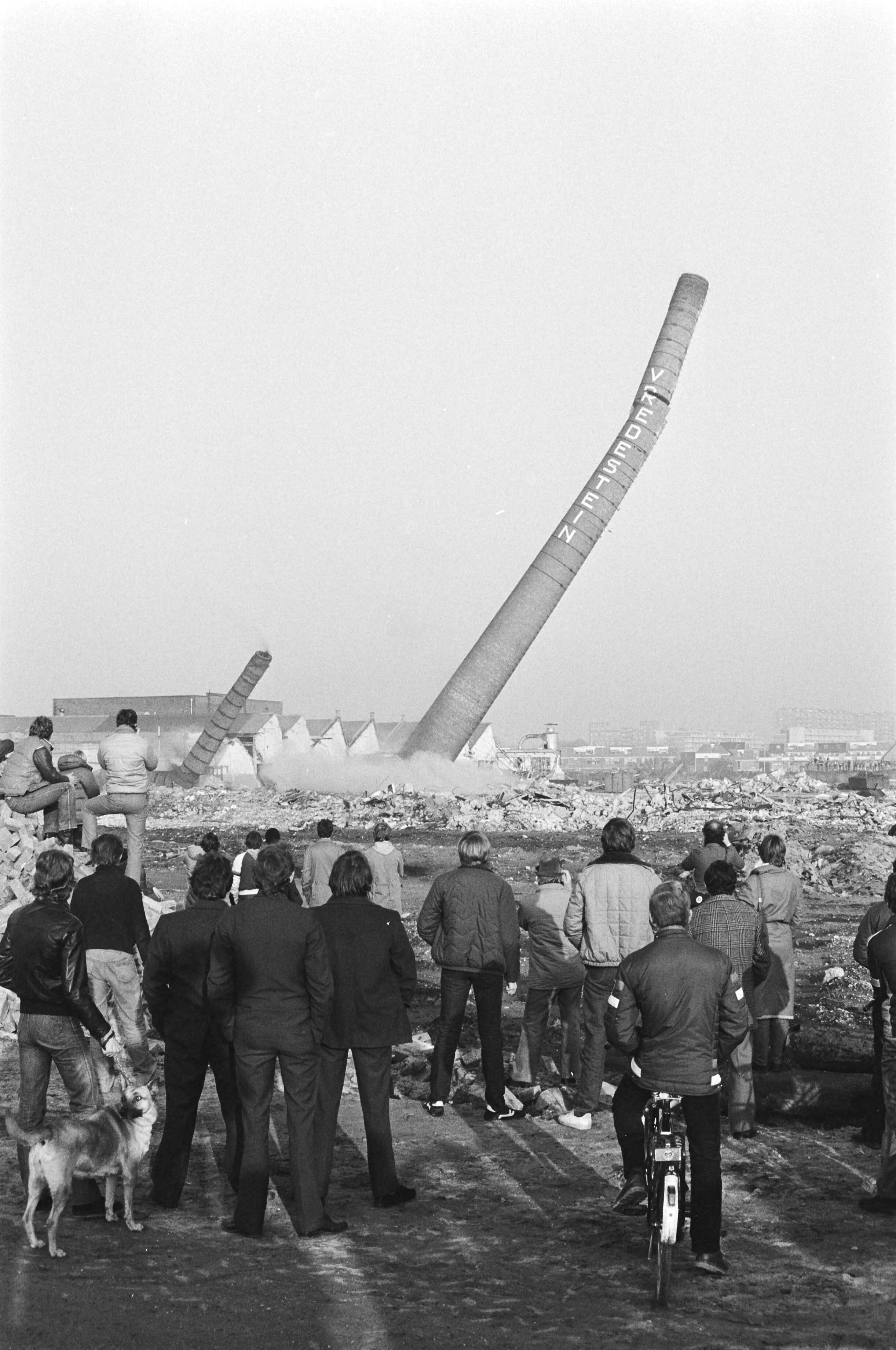 Fotocollectie Anefo — Twee grote schoorstenen van voormalige Vredestein-fabriek in Den Haag opgeblazen — Foto: Dijk, Hans van / Anefo. Licentie: Set B: Rechtenvrij / Publiek Domein. Bron: Nationaal Archief. http://hdl.handle.net/10648/ad0d859e-d0b4-102d-bcf8-003048976d84