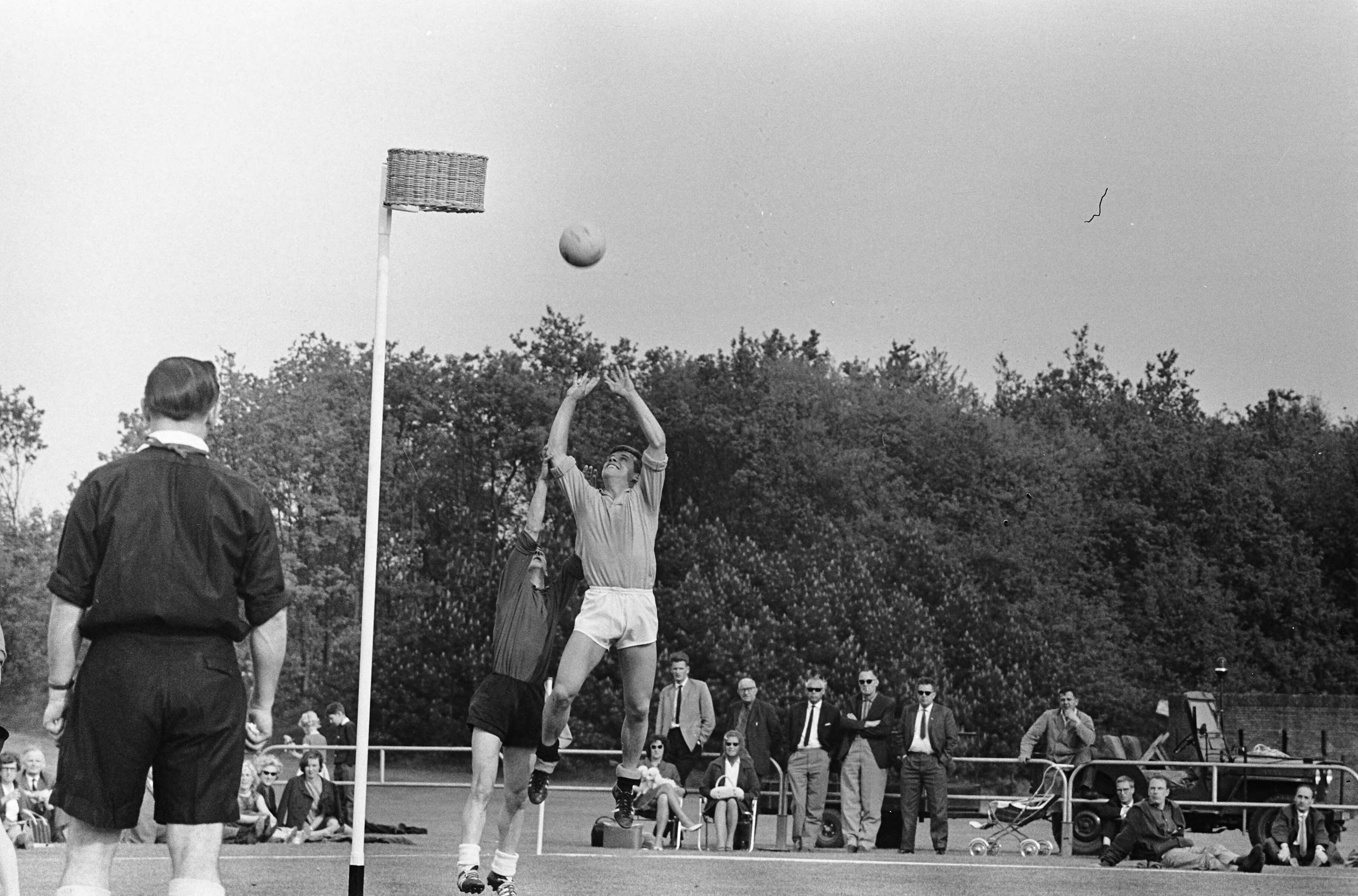 Fotocollectie Anefo — Korfbal. Nederland tegen België 8-2. Spelmoment, Harry de Voos scoort — Foto: Kroon, Ron / Anefo. Licentie: Set B: Rechtenvrij / Publiek Domein. Bron: Nationaal Archief. http://hdl.handle.net/10648/aaa9b8cc-d0b4-102d-bcf8-003048976d84