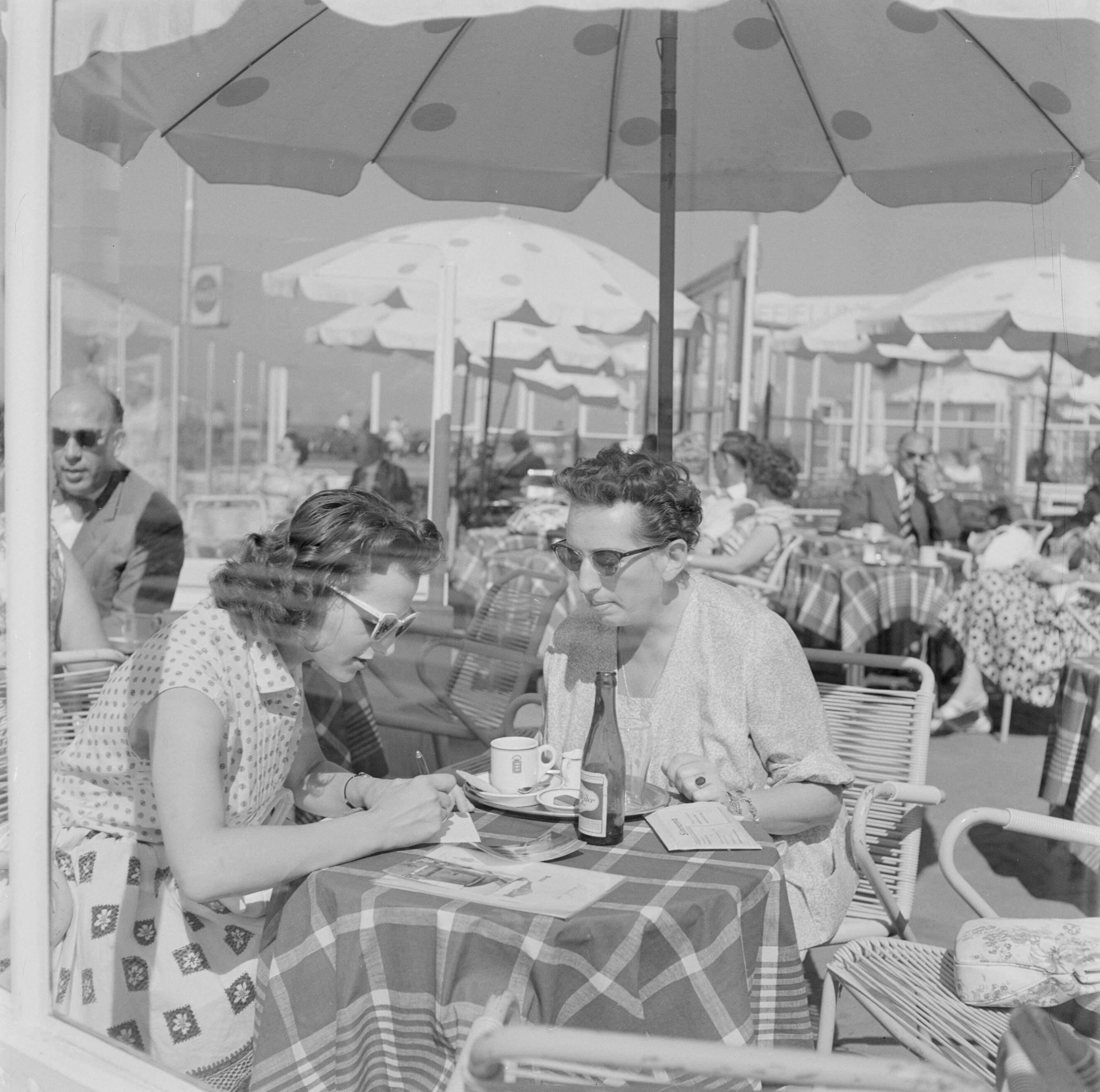 Scheveningen. — Een man en een vrouw op een terras aan de boulevard van Scheveningen — Foto: Poll, Willem van de. Licentie: Set B: Rechtenvrij / Publiek Domein. Bron: Nationaal Archief. http://hdl.handle.net/10648/aeceee90-d0b4-102d-bcf8-003048976d84
