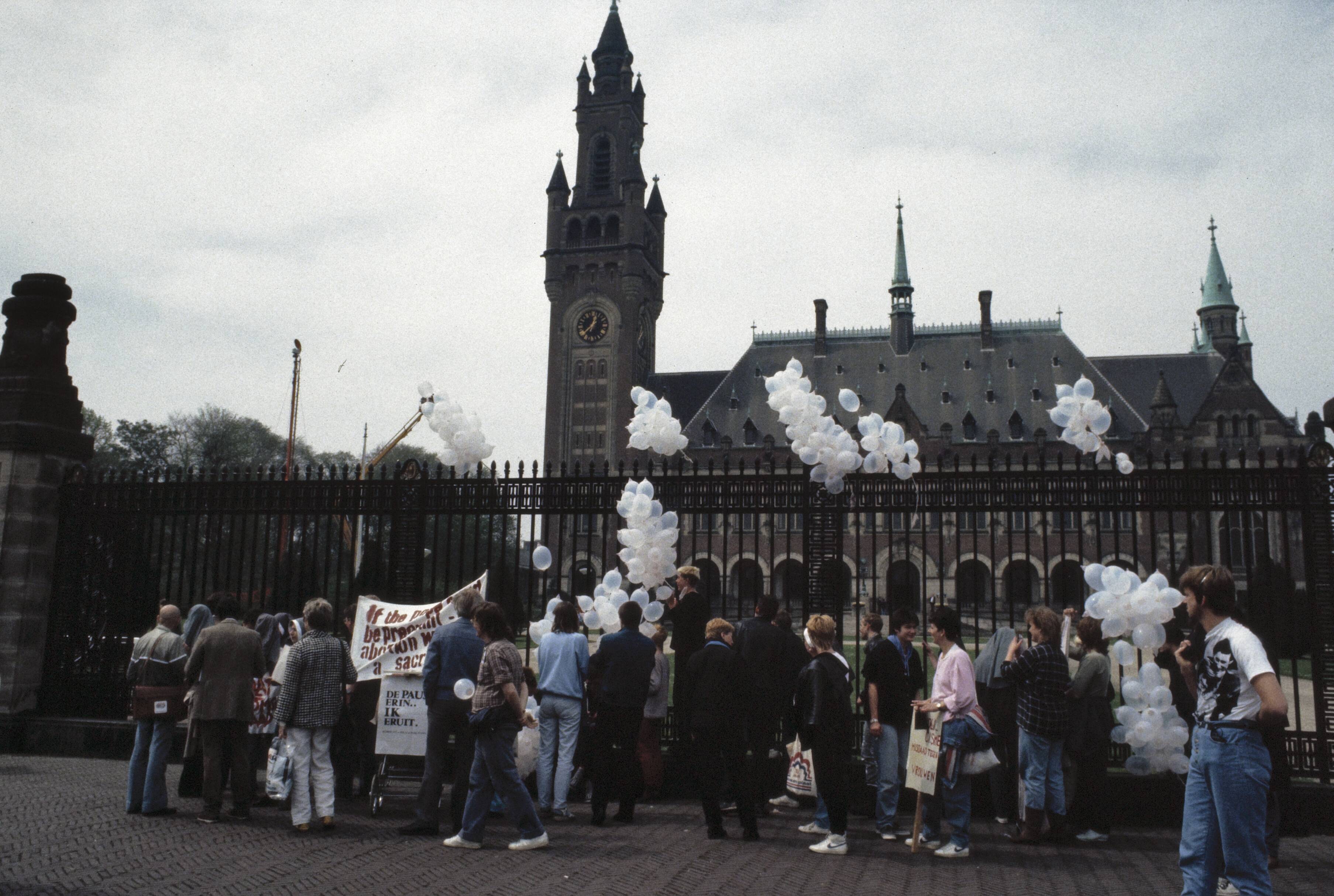 Fotocollectie Anefo — Pausbezoek aan Nederland; demonstranten tegen de Paus bij het Vredespaleis in Den Haag — Foto: Bogaerts, Rob / Anefo. Licentie: Set B: Rechtenvrij / Publiek Domein. Bron: Nationaal Archief. http://hdl.handle.net/10648/ad8baa3c-d0b4-102d-bcf8-003048976d84