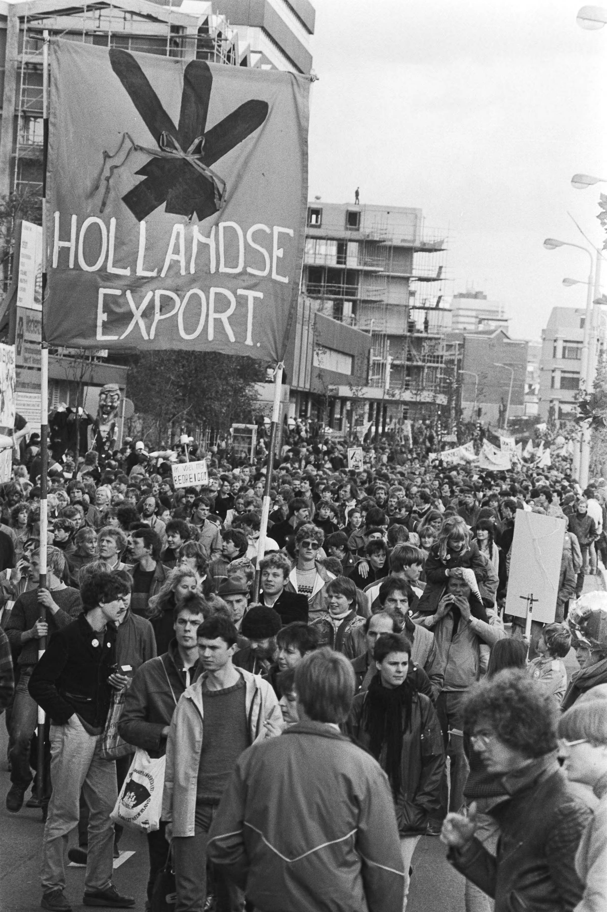 Vredesdemonstratie Den Haag , 550.000 mensen demonstreren o.m. tegen plaatsing kruisrakette — Demonstranten voeren een spandoek "Hollandse export" mee — Foto: Antonisse, Marcel / Anefo. Licentie: Set B: Rechtenvrij / Publiek Domein. Bron: Nationaal Archief. http://hdl.handle.net/10648/ad2ff548-d0b4-102d-bcf8-003048976d84
