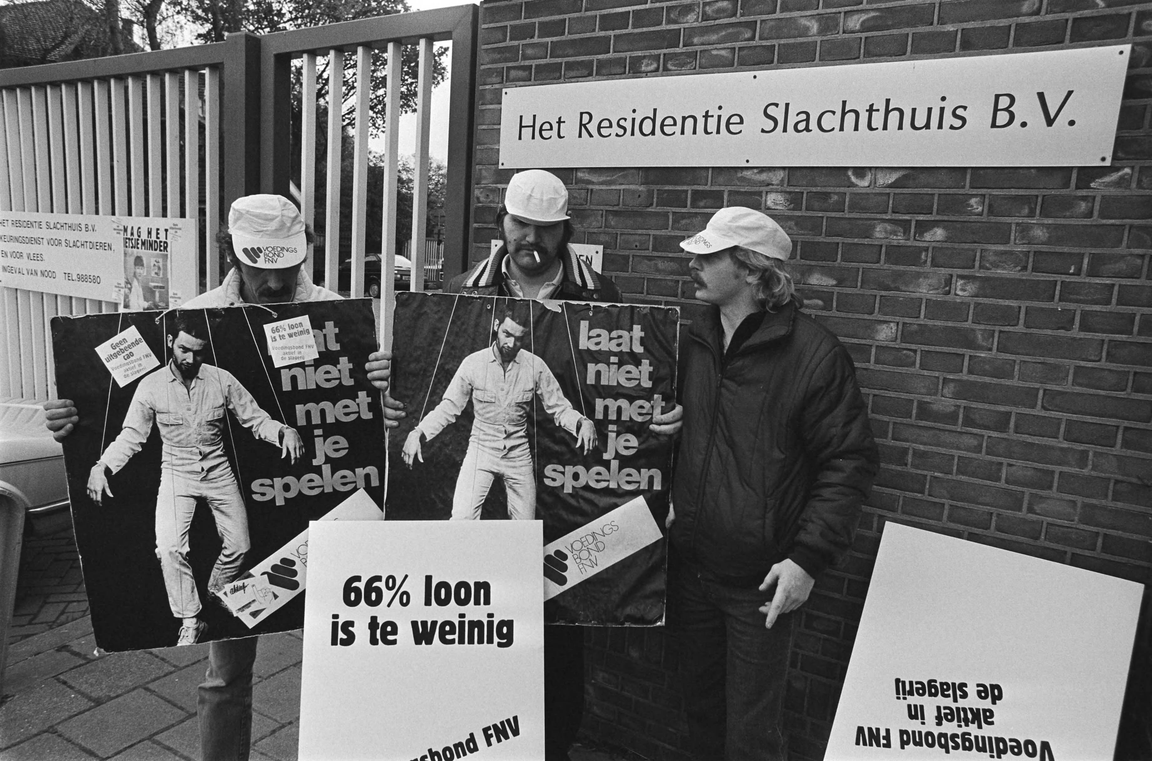 Fotocollectie Anefo — Staking bij Residentie Slachthuis in Den Haag in verband met CAO conflict; postende stakers bij de poort met affiches — Foto: Bogaerts, Rob / Anefo. Licentie: Set B: Rechtenvrij / Publiek Domein. Bron: Nationaal Archief. http://hdl.handle.net/10648/ad3eb83a-d0b4-102d-bcf8-003048976d84