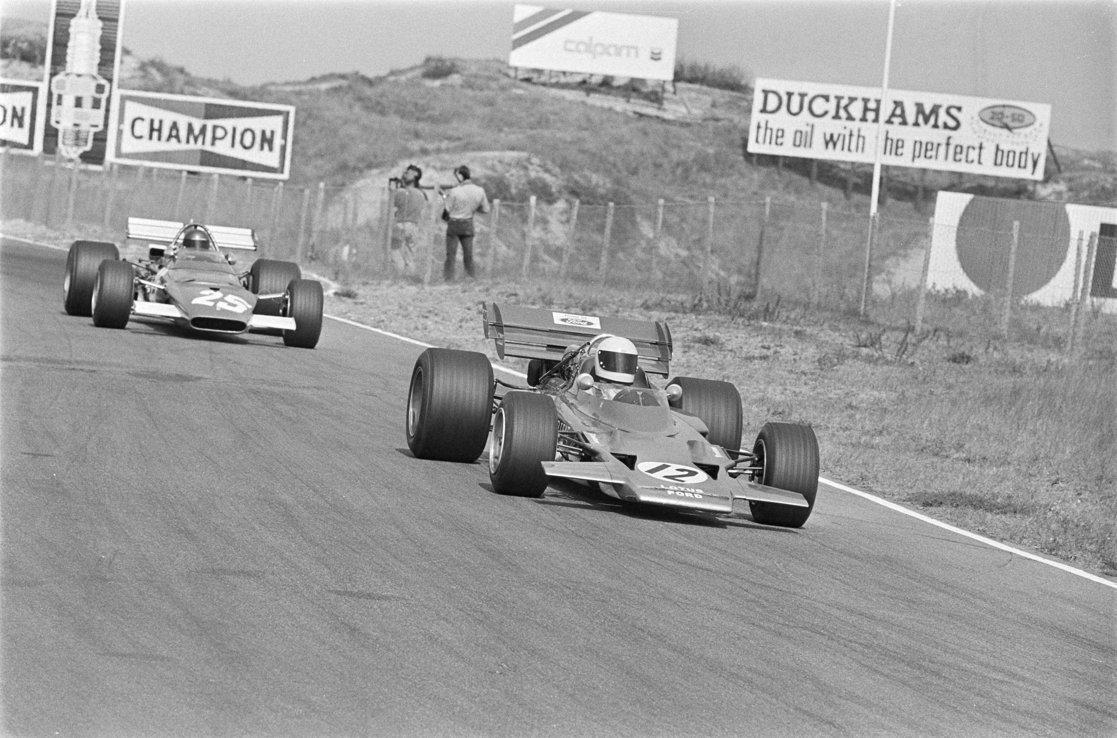 Grand Prix Zandvoort 1970, training — Grand Prix 1970 voor Formule I wagens te Zandvoort; eerste trainingsdag. John Miles (12) en Jacky Ickx (25) — Foto: Evers, Joost / Anefo. Licentie: Set B: Rechtenvrij / Publiek Domein. Bron: Nationaal Archief. http://hdl.handle.net/10648/ab9a04ee-d0b4-102d-bcf8-003048976d84