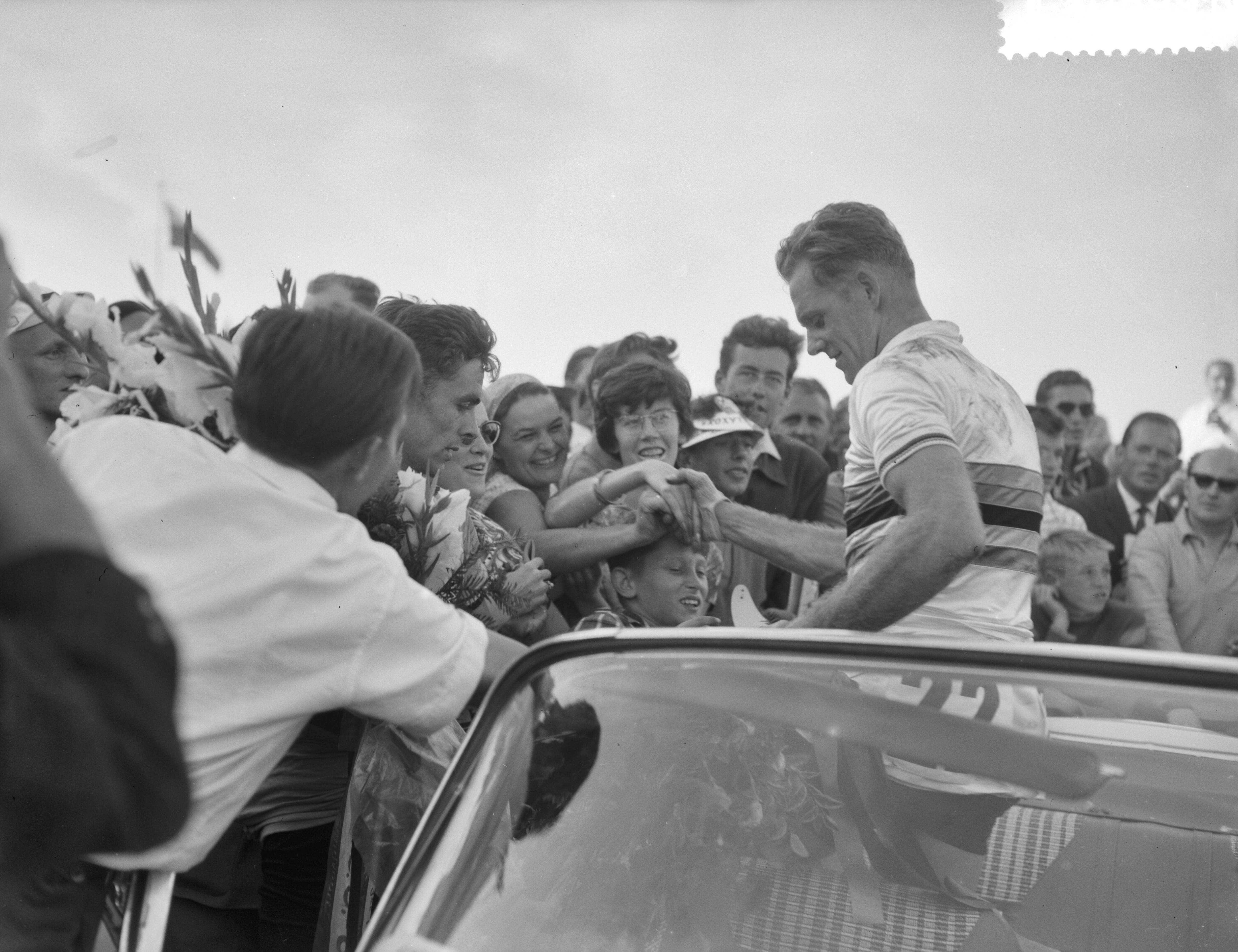 Fotocollectie Anefo — Wereldkampioenschappen wielrennen amateurs op de weg te Zandvoort, wereldkampioen Gustav-Adolf Schur (DDR) schudt handen van publiek. Links de Belg Constant Goossens die 3e werd — Foto: Rossem, Wim van / Anefo. Licentie: Set B: Rechtenvrij / Publiek Domein. Bron: Nationaal Archief. http://hdl.handle.net/10648/a99b3064-d0b4-102d-bcf8-003048976d84