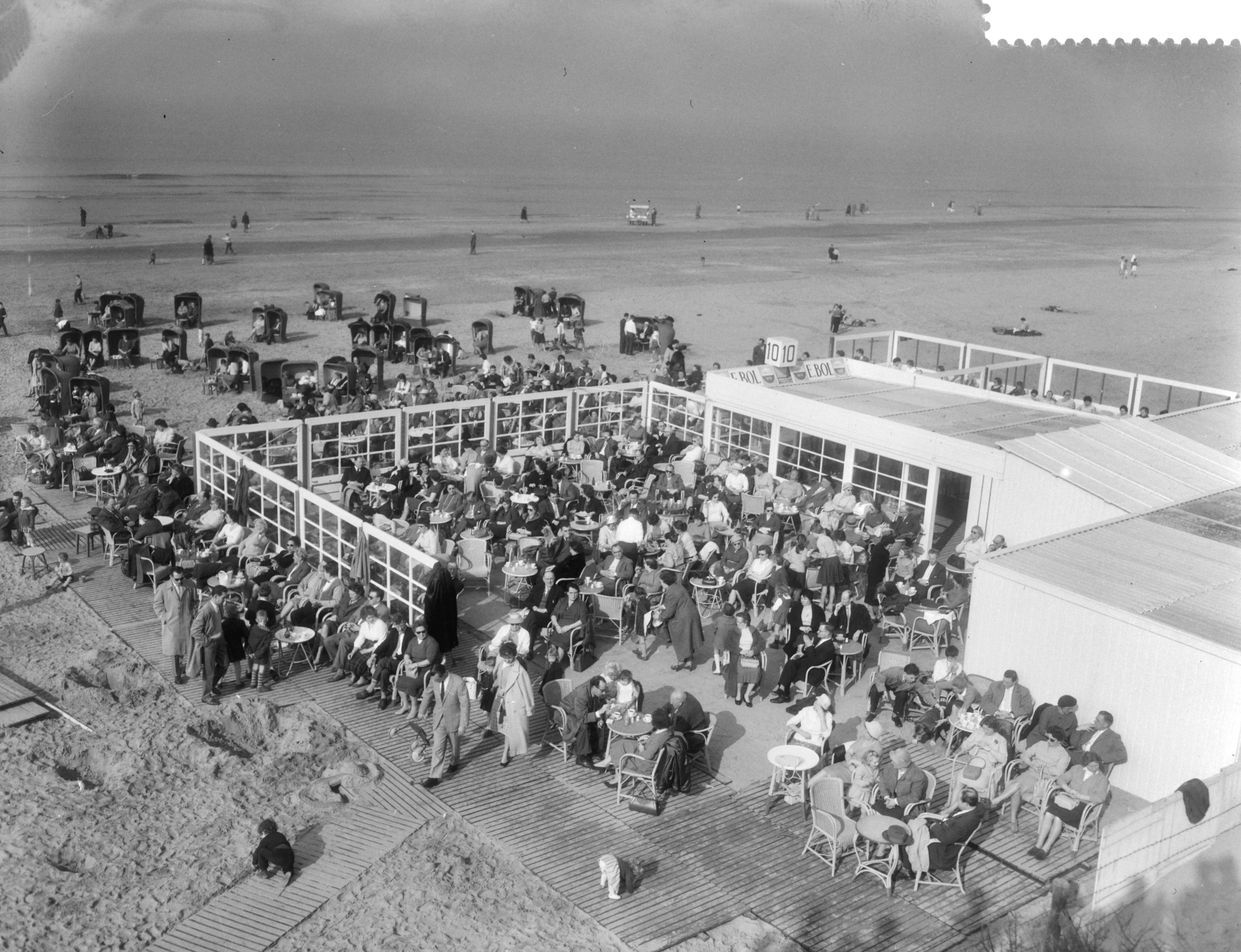Fotocollectie Anefo — Drukte aan het strand te Zandvoort i.v.m. het mooie weer. Terras van strandtent — Foto: Pot, Harry / Anefo. Licentie: Set B: Rechtenvrij / Publiek Domein. Bron: Nationaal Archief. http://hdl.handle.net/10648/a98eaca4-d0b4-102d-bcf8-003048976d84