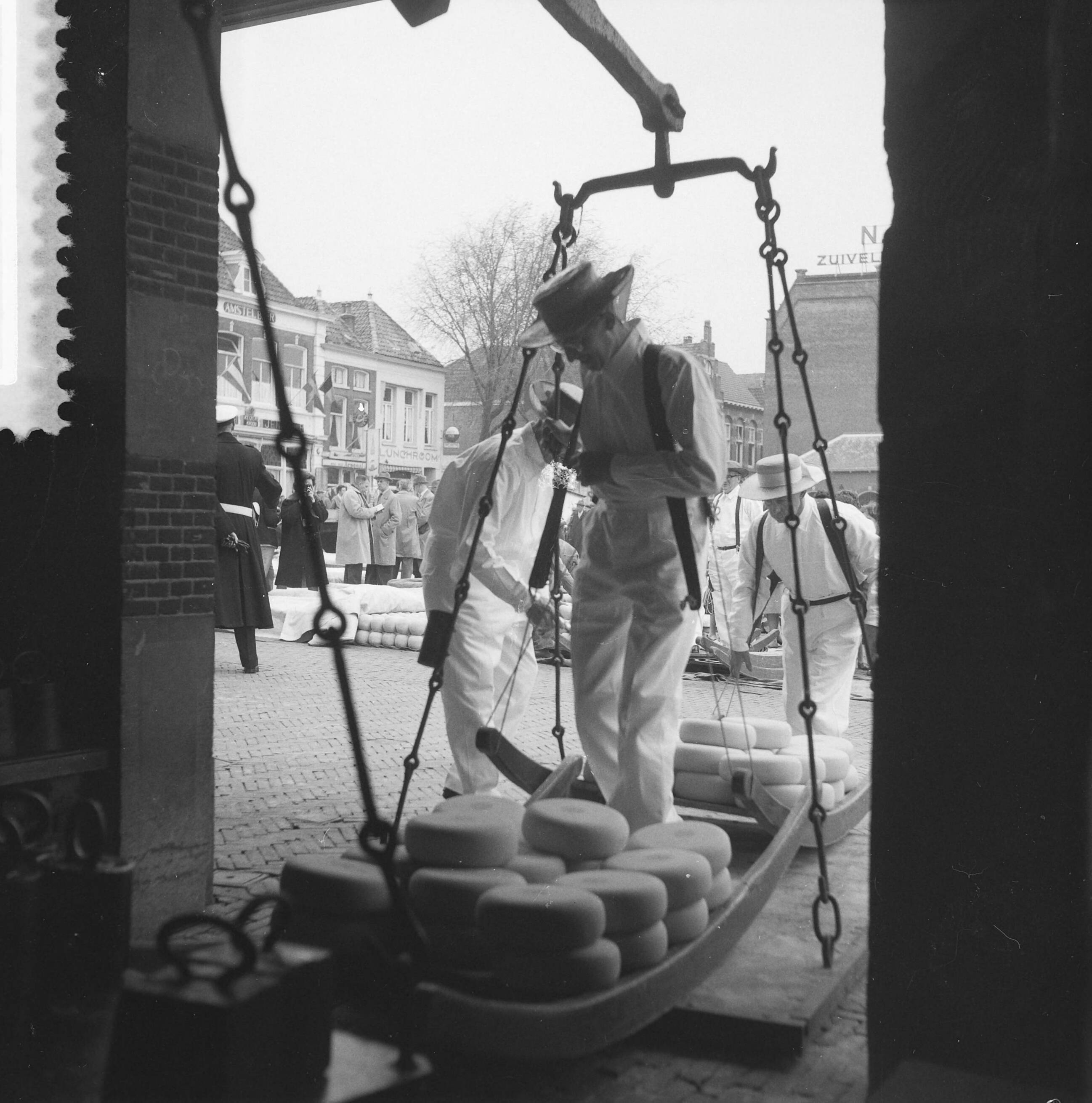 Fotocollectie Anefo — Voor de eerste maal weer Kaasmarkt te Alkmaar, afwegen van de kaas in het Waaggebouw — Foto: Pot, Harry / Anefo. Licentie: Set B: Rechtenvrij / Publiek Domein. Bron: Nationaal Archief. http://hdl.handle.net/10648/a9ac30f8-d0b4-102d-bcf8-003048976d84