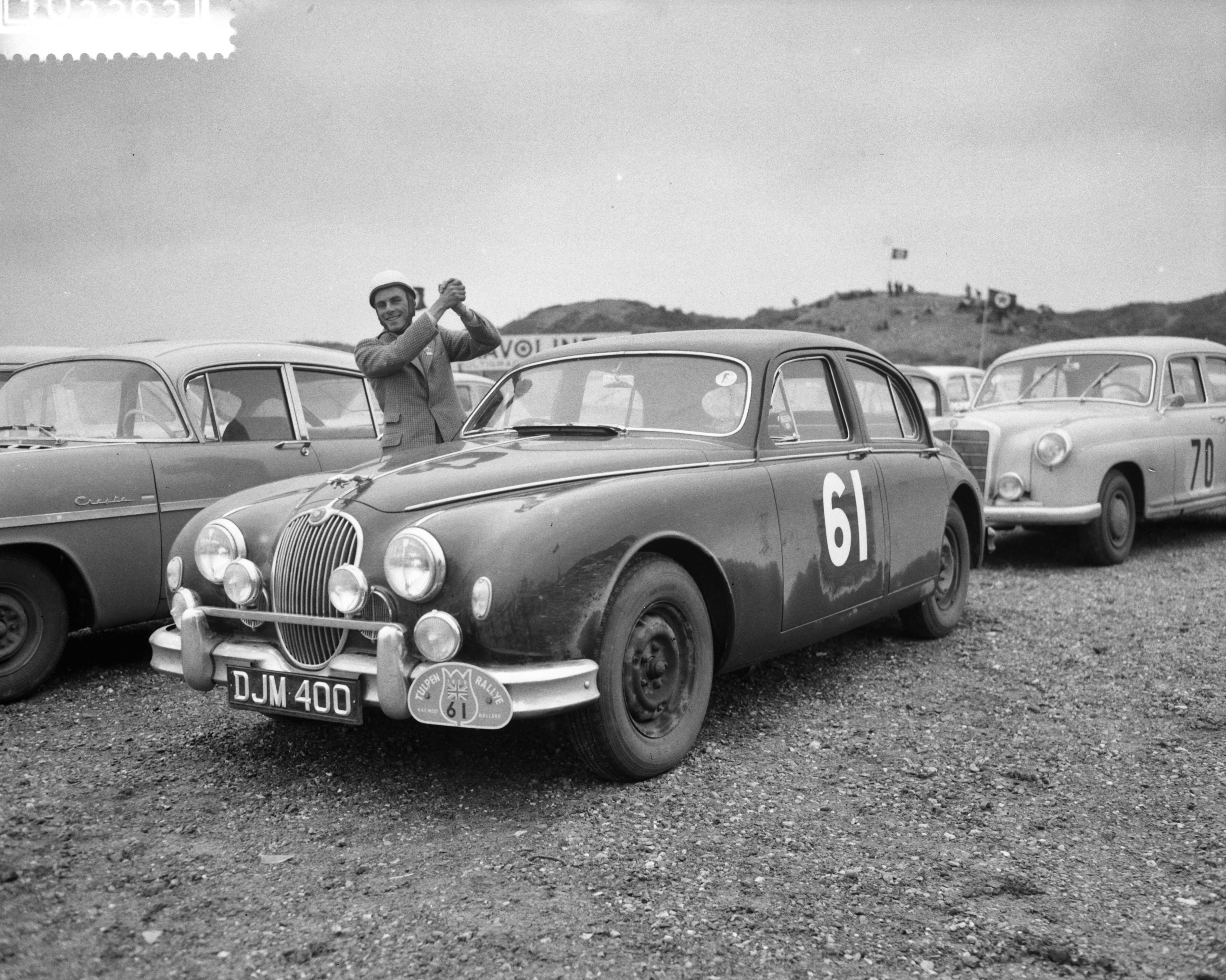 Tulpenrallye 1959 — Tulpenrallye. Einde op het circuit van Zandvoort. Algemeen winnaar D.J. Morley, samen met navigator G.E. Morley (G.B.) met Jaguar 3.4 (Startnummer 61) — Foto: Behrens, Herbert F. / Anefo. Licentie: Set B: Rechtenvrij / Publiek Domein. Bron: Nationaal Archief. http://hdl.handle.net/10648/a992dc70-d0b4-102d-bcf8-003048976d84