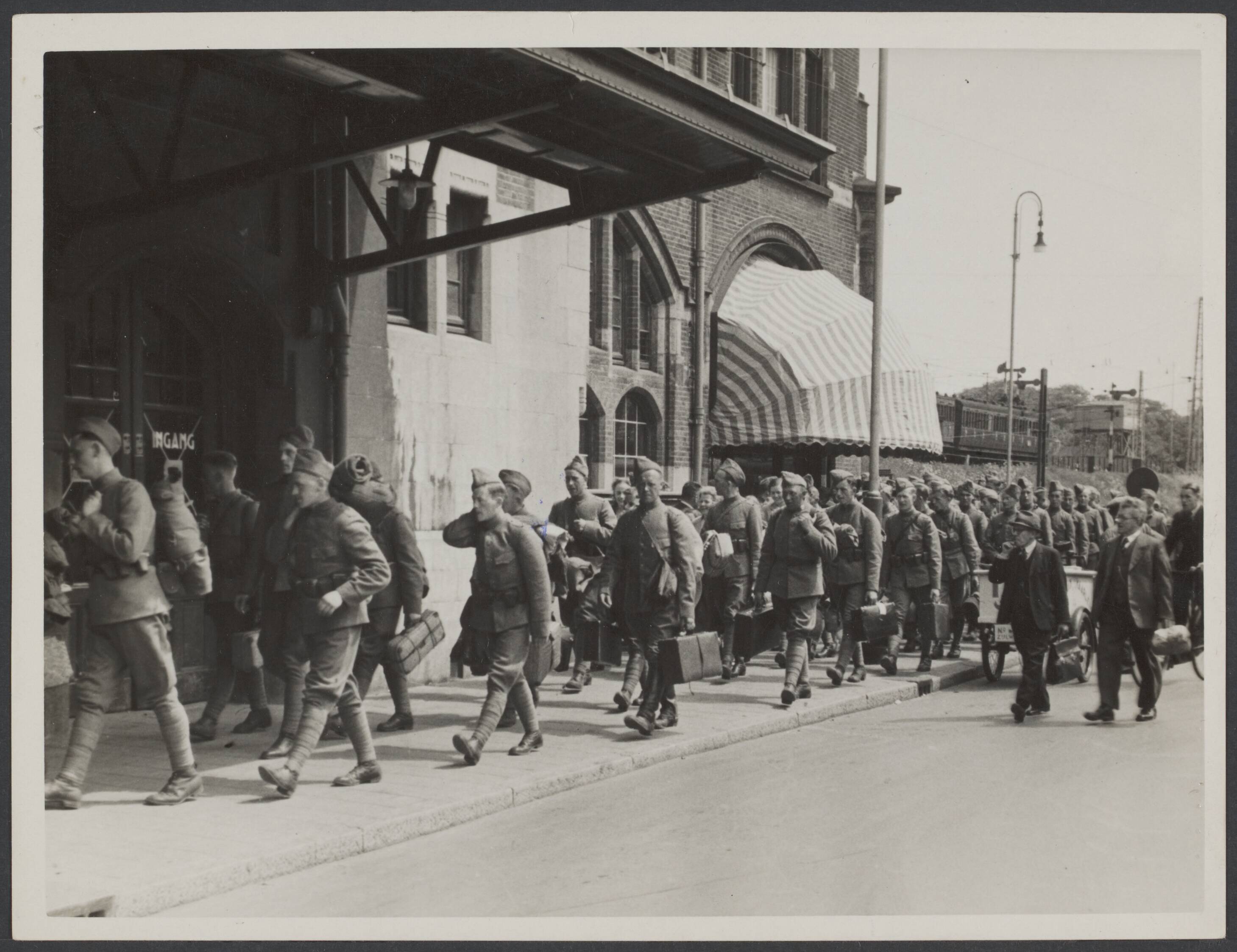 Demobilisatie 1940 — Serie: Demobllisatie Haarlem. Op weg naar het station — Foto: Valks, H.J.M. / Spaarnestad. Licentie: Set B: Rechtenvrij / Publiek Domein. Bron: Nationaal Archief. http://hdl.handle.net/10648/32b6a06a-e9fb-e612-8b0e-261447fdb826