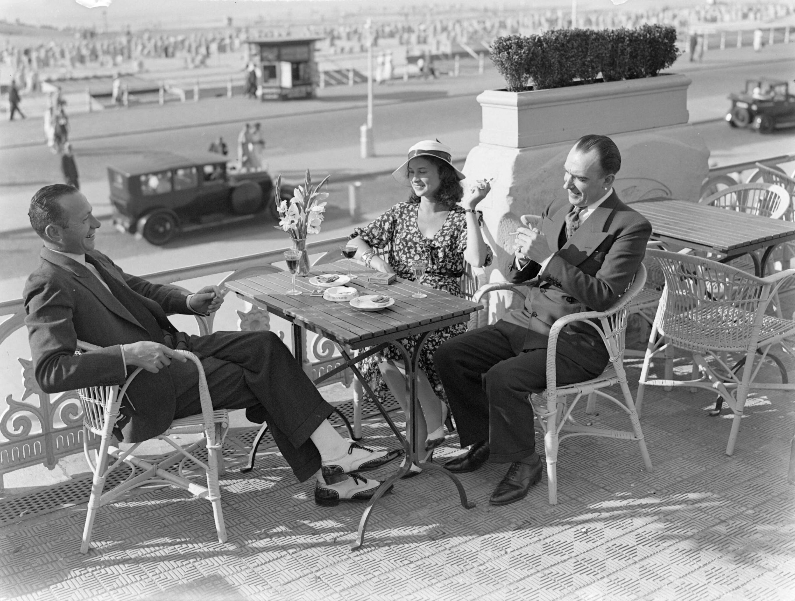 Scheveningen. — Een vrouw (mevrouw Ott?) en twee mannen op een terras aan de boulevard in Scheveningen — Foto: Poll, Willem van de. Licentie: Set B: Rechtenvrij / Publiek Domein. Bron: Nationaal Archief. http://hdl.handle.net/10648/ae9ab224-d0b4-102d-bcf8-003048976d84