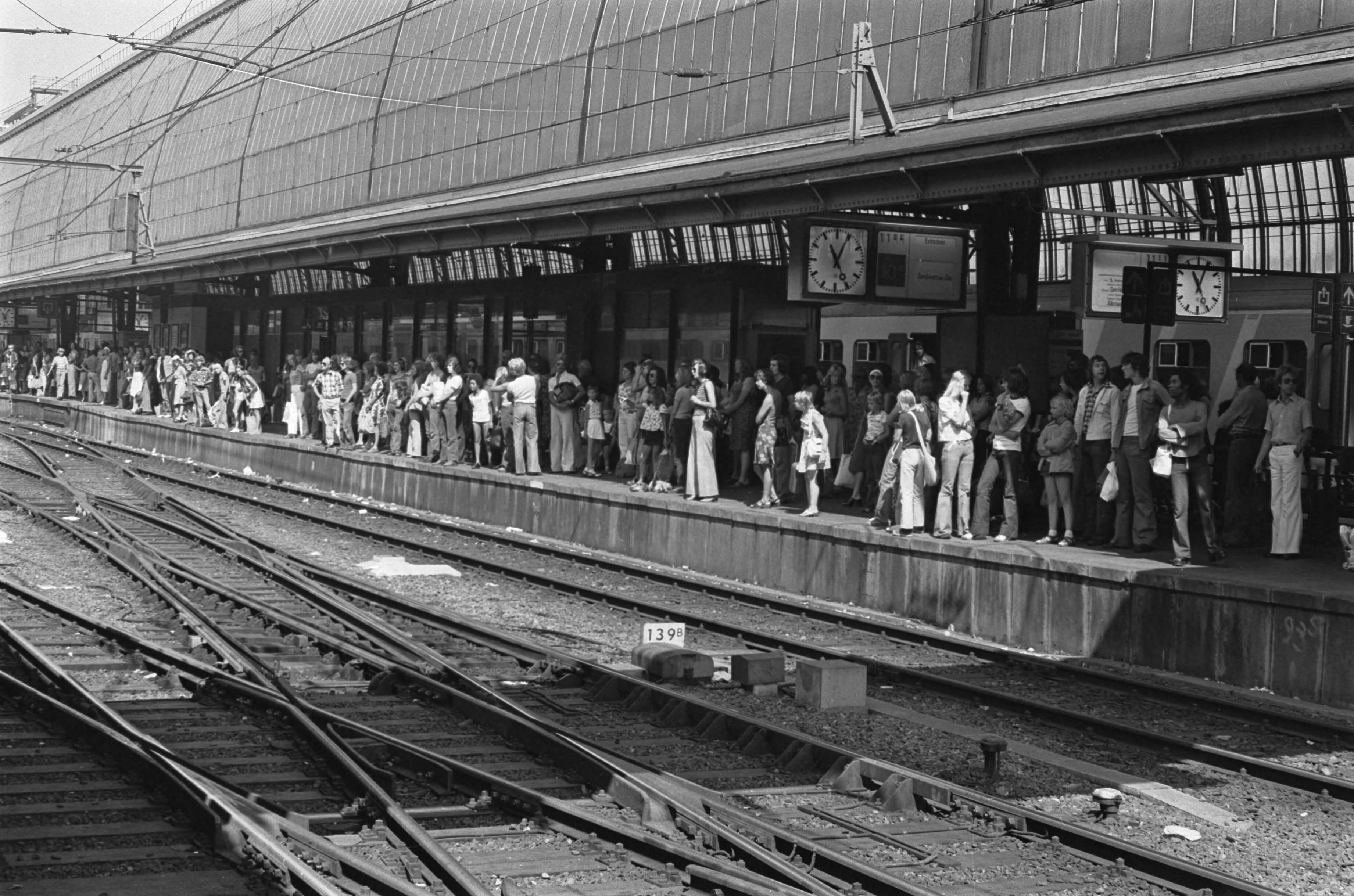 Warmste zomerdag in Amsterdam — Rij wachtenden op een perron van het Centraal Station voor de trein richting Zandvoort — Foto: Peters, Hans / Anefo. Licentie: Set B: Rechtenvrij / Publiek Domein. Bron: Nationaal Archief. http://hdl.handle.net/10648/ac6ee420-d0b4-102d-bcf8-003048976d84