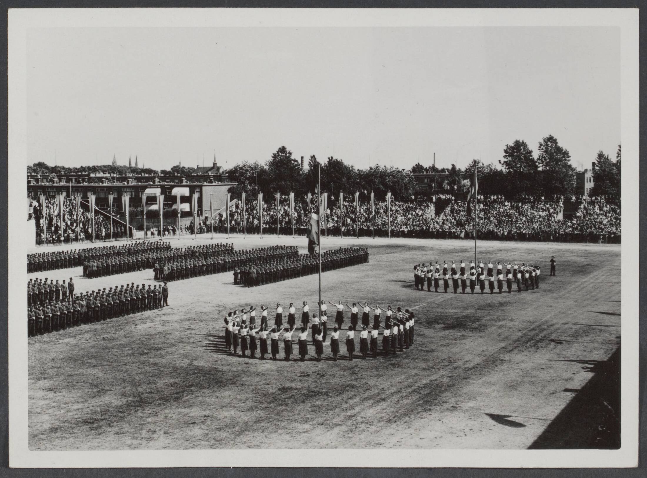 Arbeidsdienst. Waaronder "Nederlandse Arbeidsdienst" en "Vreugde en Arbeid" ("Fut door lol" 81). Ook opbouwdienst 1940/41. — 2. "Feierstunde" van de Reichsarbeitsdienst in Den Haag. Het hijsen van de vlaggen — Foto: Stapf Bilderdienst. Licentie: Set B: Rechtenvrij / Publiek Domein. Bron: Nationaal Archief. http://hdl.handle.net/10648/a4d53672-e02c-861c-37ed-a053eb4fff45