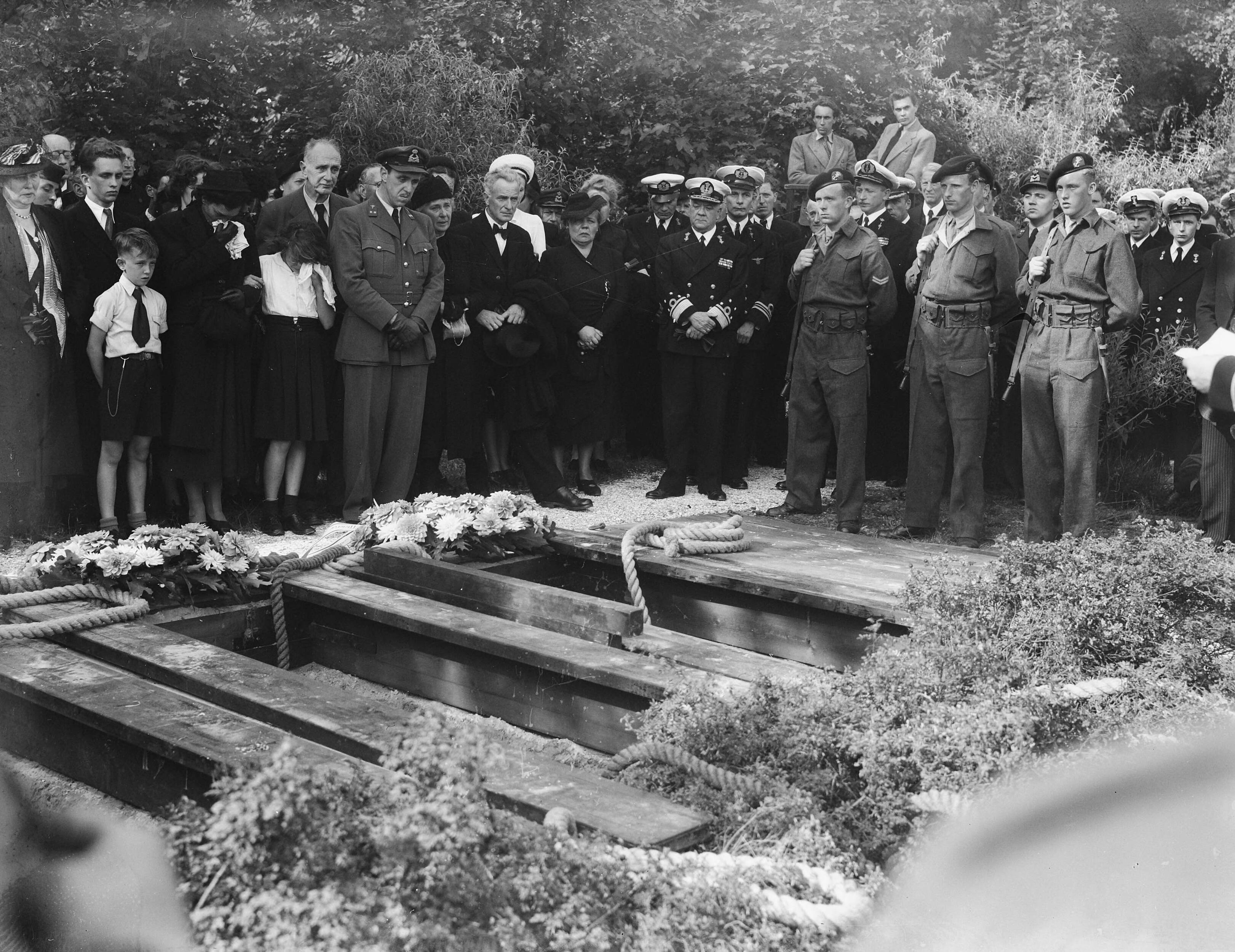 Fotocollectie Anefo — Begrafenis van 3 marine-officieren in Den Haag. Op de begraafplaats — Foto: Merk, Ben / Anefo. Licentie: Set B: Rechtenvrij / Publiek Domein. Bron: Nationaal Archief. http://hdl.handle.net/10648/a8ba509e-d0b4-102d-bcf8-003048976d84