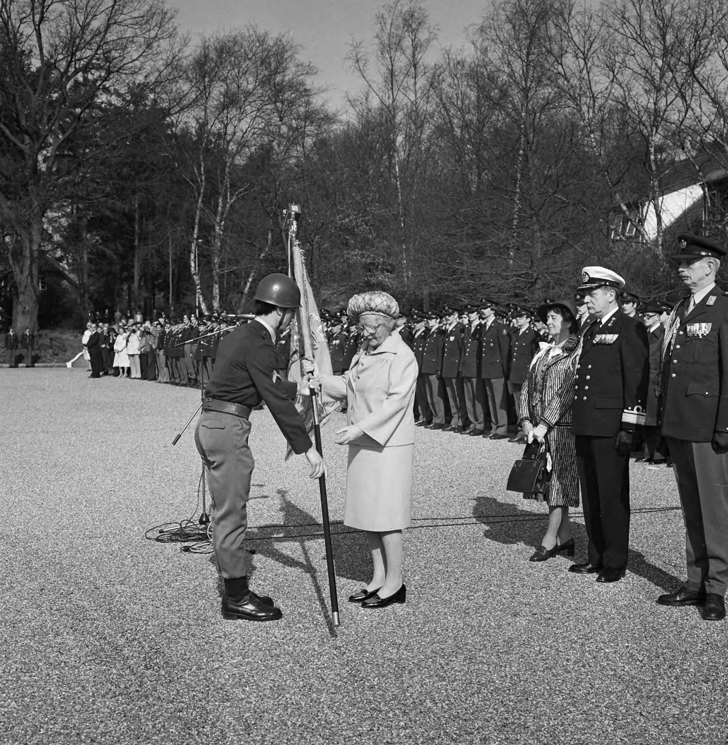 Hare Majesteit onthult het borstbeeld van Korporaal J. van Oudheusden en reikt het vaandel uit aan het Regiment Geneeskundige Troepen in de Kazerne aan de Noodweg te Hilversum — De overhandiging van het vaandel — Foto: Croes, Rob C. / Anefo. Licentie: Set B: Rechtenvrij / Publiek Domein. Bron: Nationaal Archief. http://hdl.handle.net/10648/acc7f1dc-d0b4-102d-bcf8-003048976d84