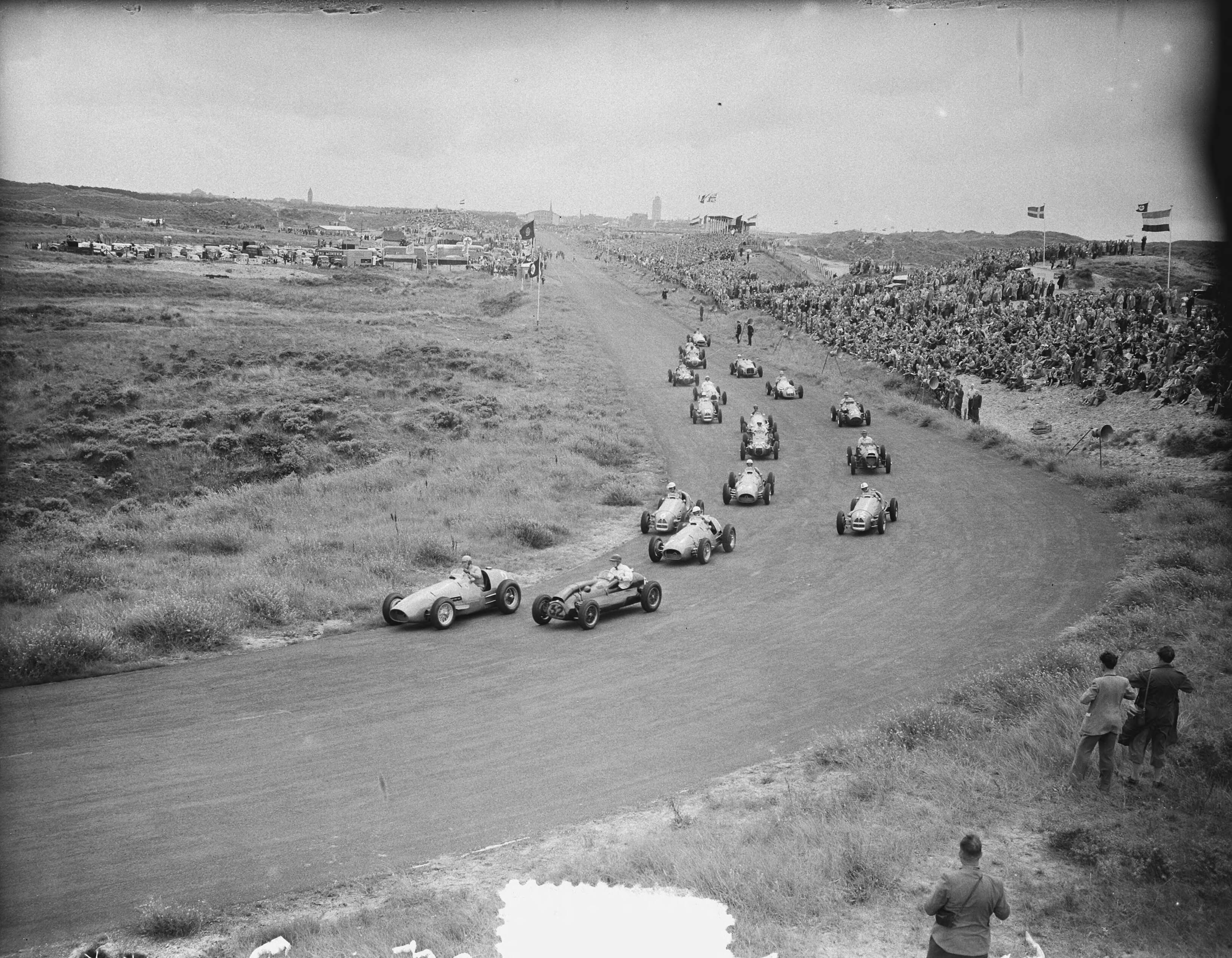 Grote Prijs van Nederland 1952 — Grote Prijs van Nederland op het circuit van Zandvoort. Eerste bocht — Foto: Bilsen, Joop van / Anefo. Licentie: Set B: Rechtenvrij / Publiek Domein. Bron: Nationaal Archief. http://hdl.handle.net/10648/a8fe709e-d0b4-102d-bcf8-003048976d84