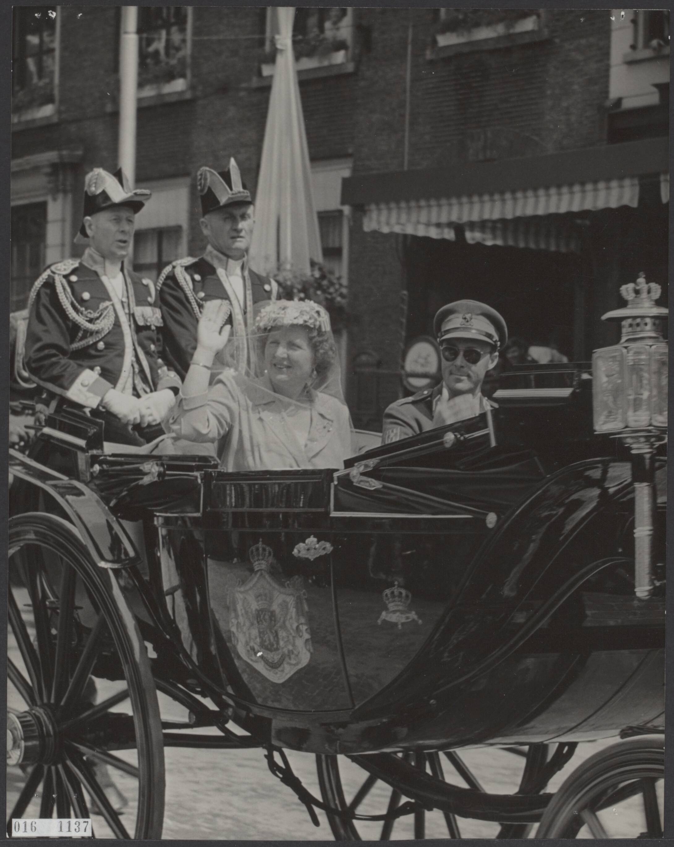 Fotocollectie Elsevier Binnenland — Bezoek van koningin Juliana en prins Bernhard aan Breda t.g.v. het 700-jarig bestaan. Het koninklijk paar in open caleche rijdt door Breda — Foto: Fotograaf Onbekend / Anefo. Licentie: Set B: Rechtenvrij / Publiek Domein. Bron: Nationaal Archief. http://hdl.handle.net/10648/adbb7ee2-d0b4-102d-bcf8-003048976d84